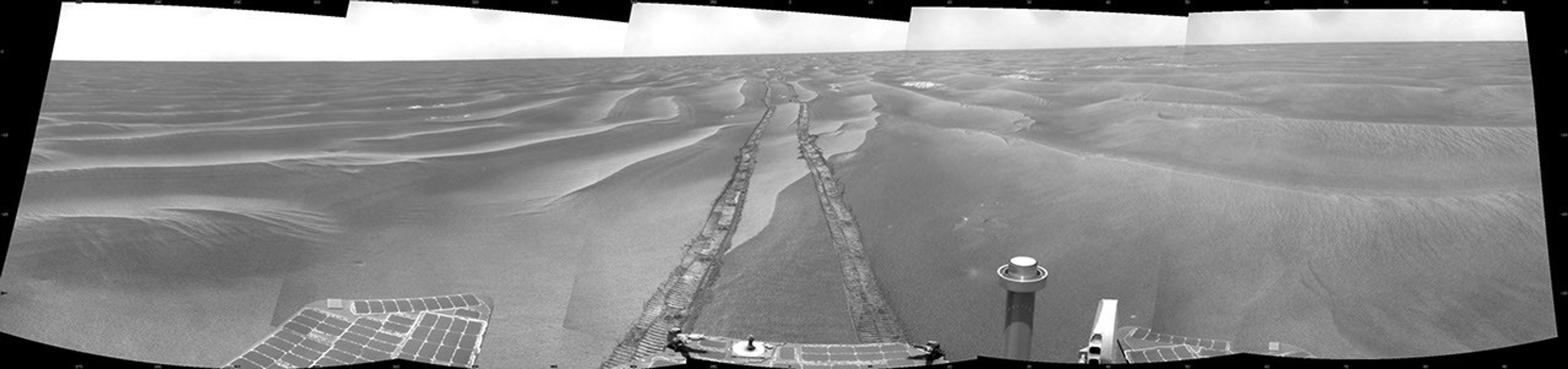 NASA's Mars Exploration Rover Opportunity took images combined into this cylindrical full-circle view of Mars' Meridiani Planum region includes dark-toned sand ripples and small exposures of lighter-toned bedrock during Feb. 13, 2009.