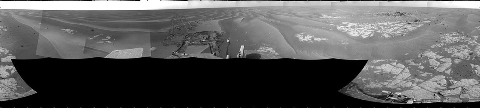 NASA's Mars Exploration Rover Opportunity took images combined into this cylindrical full-circle view of Mars' Meridiani Planum region includes dark-toned sand ripples and small exposures of lighter-toned bedrock during March 12, 2009.