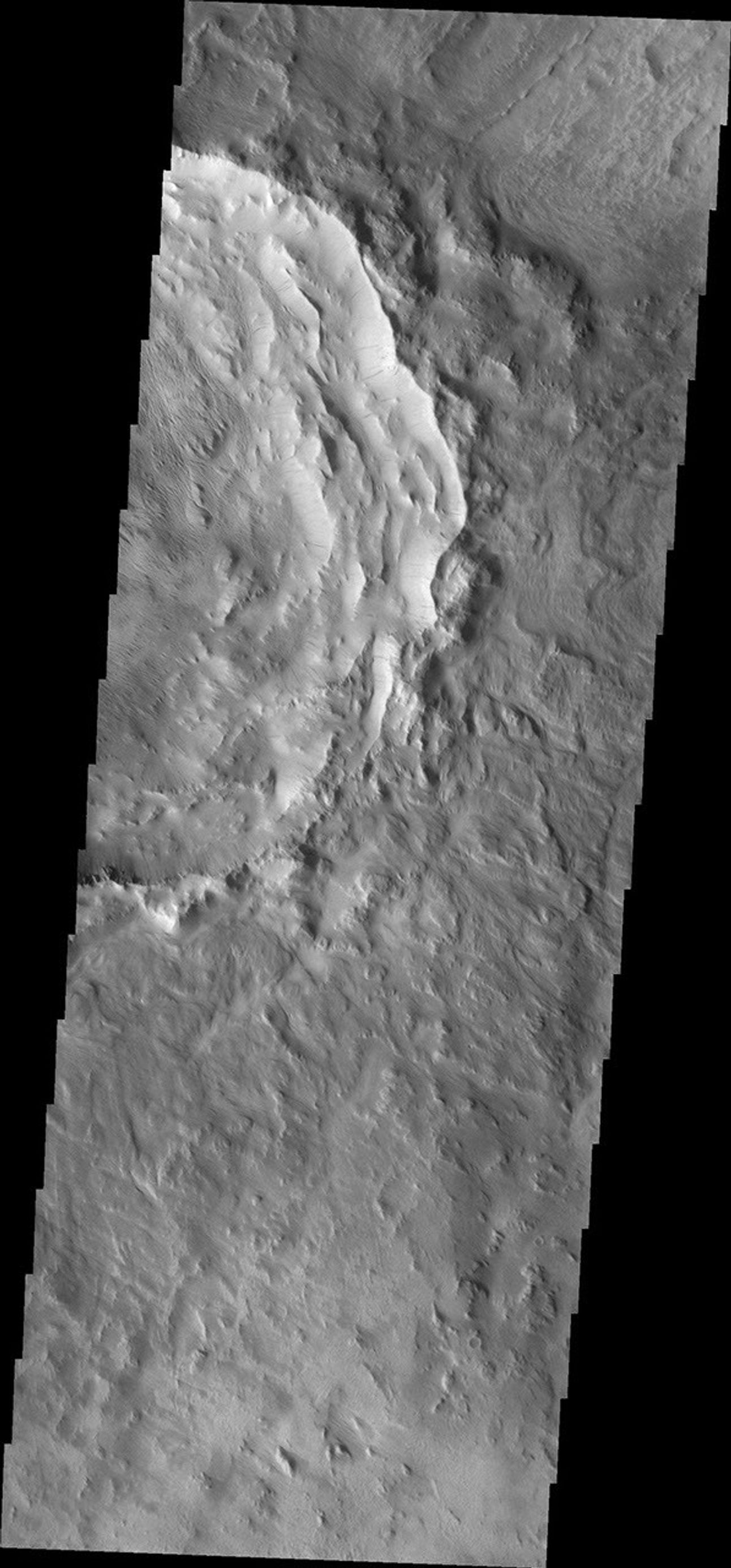 This image from NASA's Mars Odyssey shows dark slope streaks within a crater in Terra Sirenum. Wind erosion of materials on the floor of the crater.