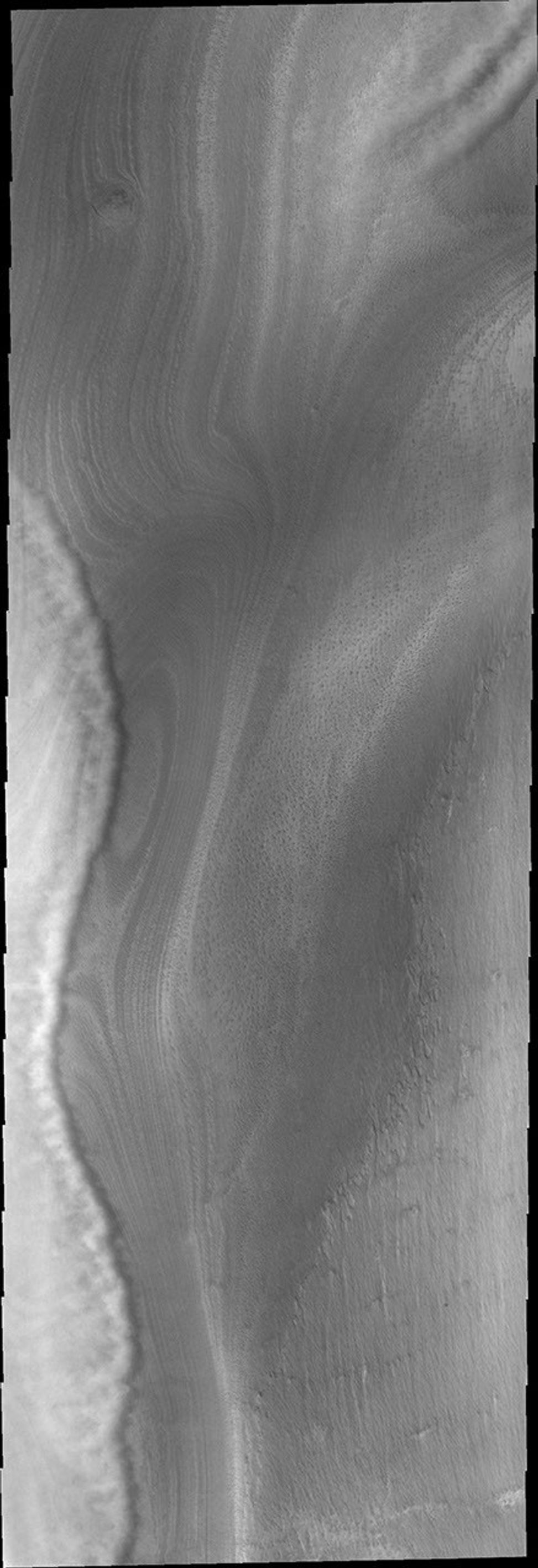 This image from NASA's Mars Odyssey shows the south pole of Mars featuring the edge of a front of clouds. These clouds are near enough to the surface to be affected by surface topography.
