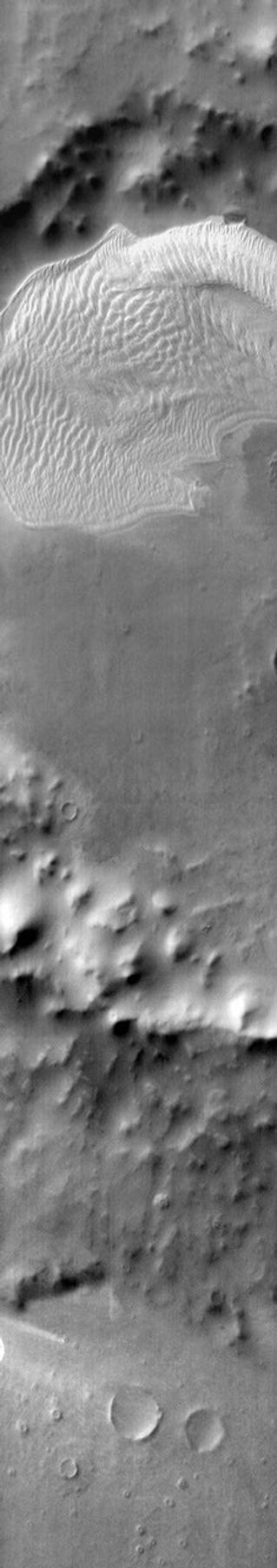 This daytime infrared image shows the large sand sheet on the floor of Charlier Crater on Mars as seen by NASA's Mars Odyssey spacecraft. The brightness is due to the warmth of the sand during the day.