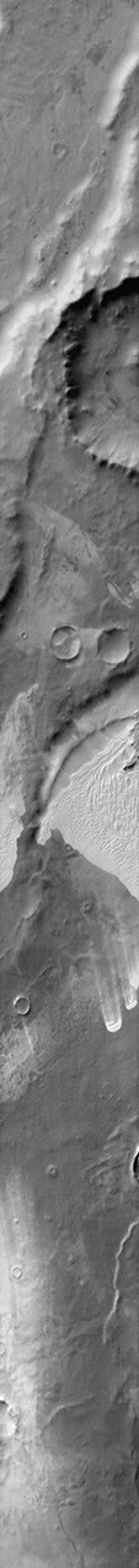 This 2001 Mars Odyssey image shows sand that has been trapped in several depressions in this region of Terra Cimmeria near the Thyles Rupes on Mars.