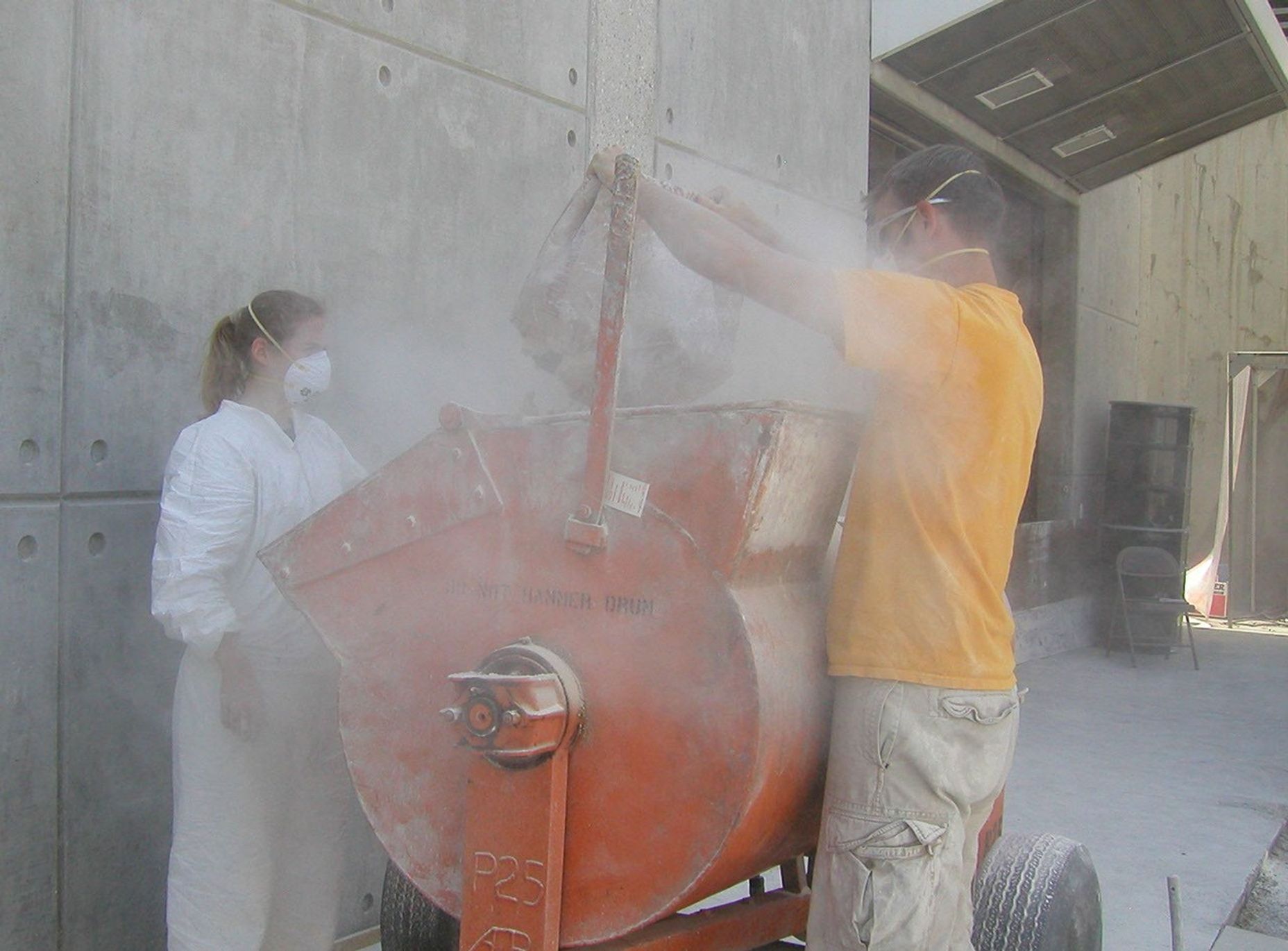 Rover team members Kim Lichtenberg (left) and Mike Seibert fill a mixer with powdered clay and diatomaceous earth, a combination found to offer physical properties similar to the soil where NASA's rover Spirit is embedded on Mars.