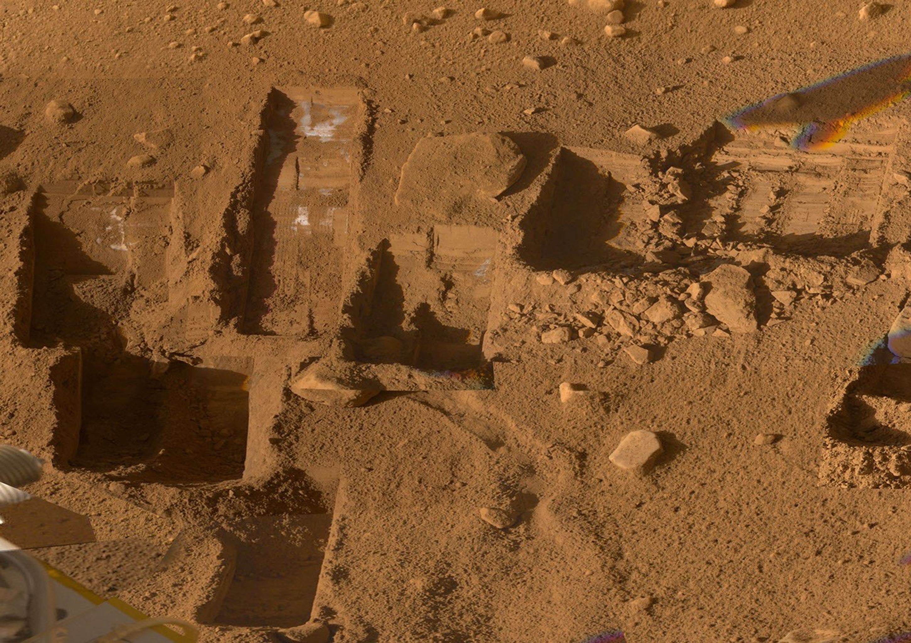 Several of the trenches dug by NASA's Phoenix Mars Lander are displayed in this approximately true color mosaic of images from the lander's Surface Stereo Imager camera.