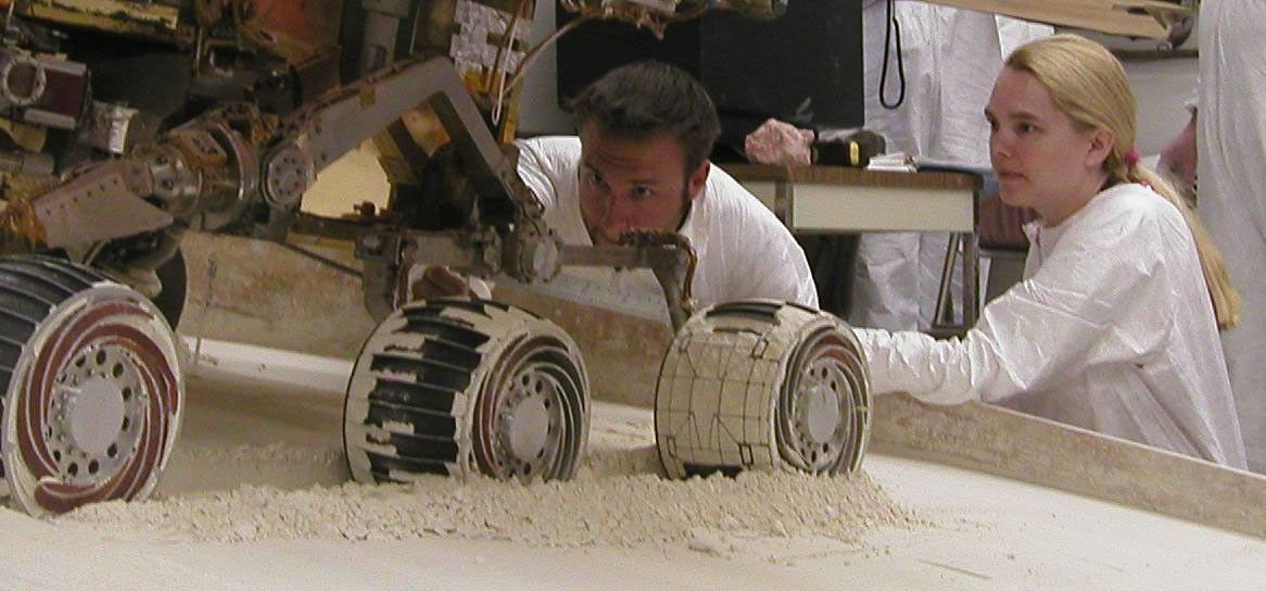 Mike Seibert and Sharon Laubach, engineers on NASA's Mars Exploration Rover team at the Jet Propulsion Laboratory, Pasadena, check the exact position of a test rover in preparation for the next test of a possible maneuver for Spirit to use on Mars.