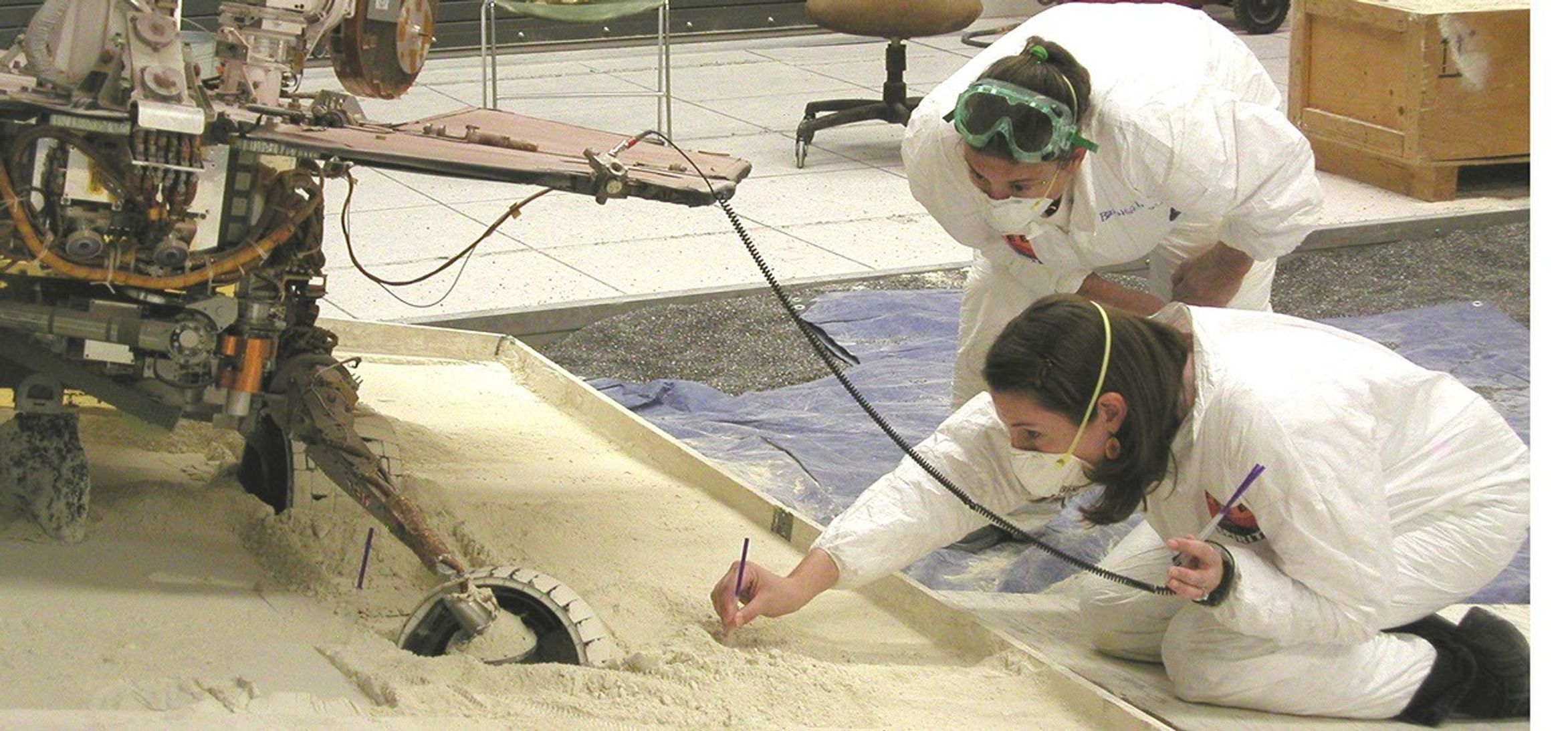 Mars Exploration Rover team members at NASA's Jet Propulsion Laboratory, Pasadena, Calif., prepare an experiment on July 13, 2009, for assessing how a test rover moves when embedded in loose soil and commanded to drive backward with wheels turned.