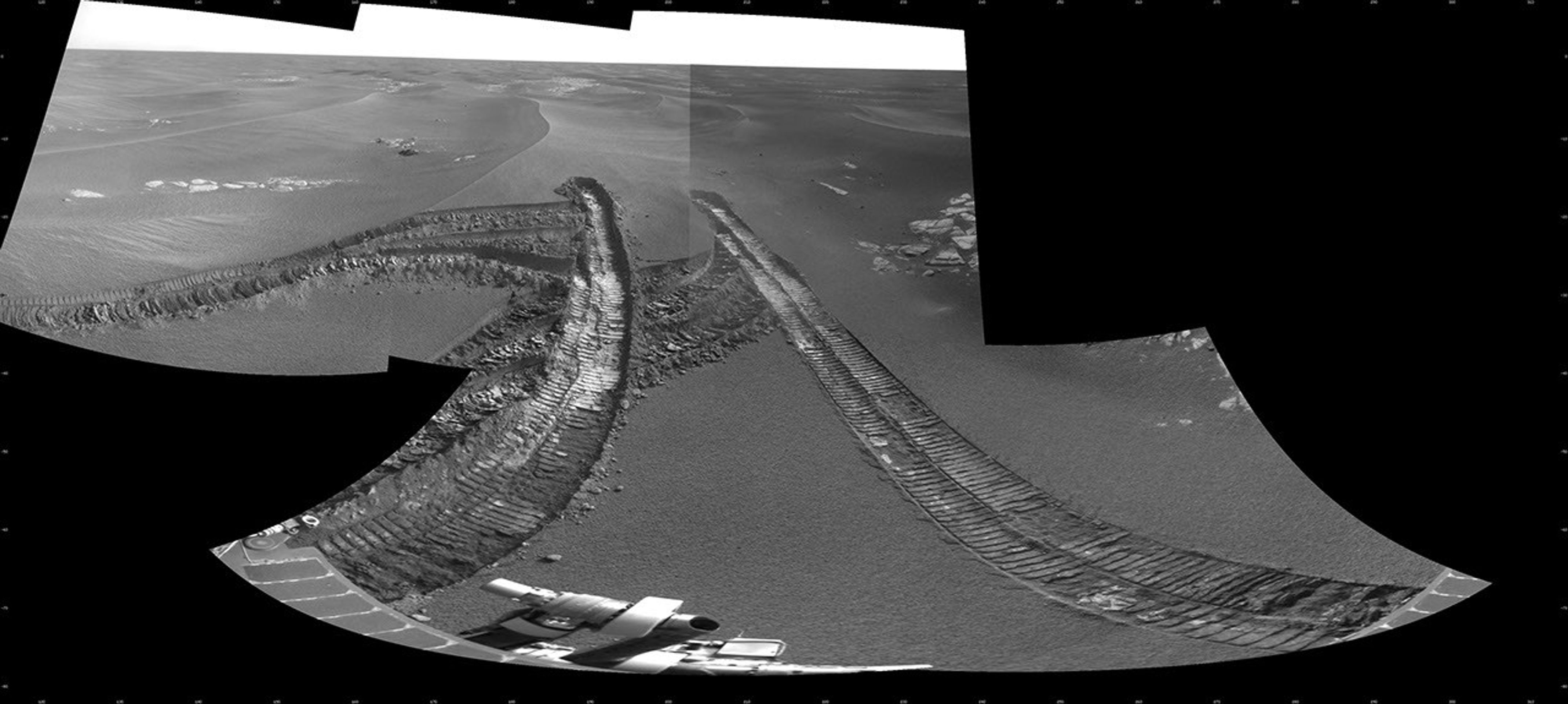 This view from the navigation camera on NASA's Mars Exploration Rover Opportunity shows tracks left by backing out of a wind-formed ripple after the rover's wheels had started to dig too deeply into the dust and sand of the ripple.