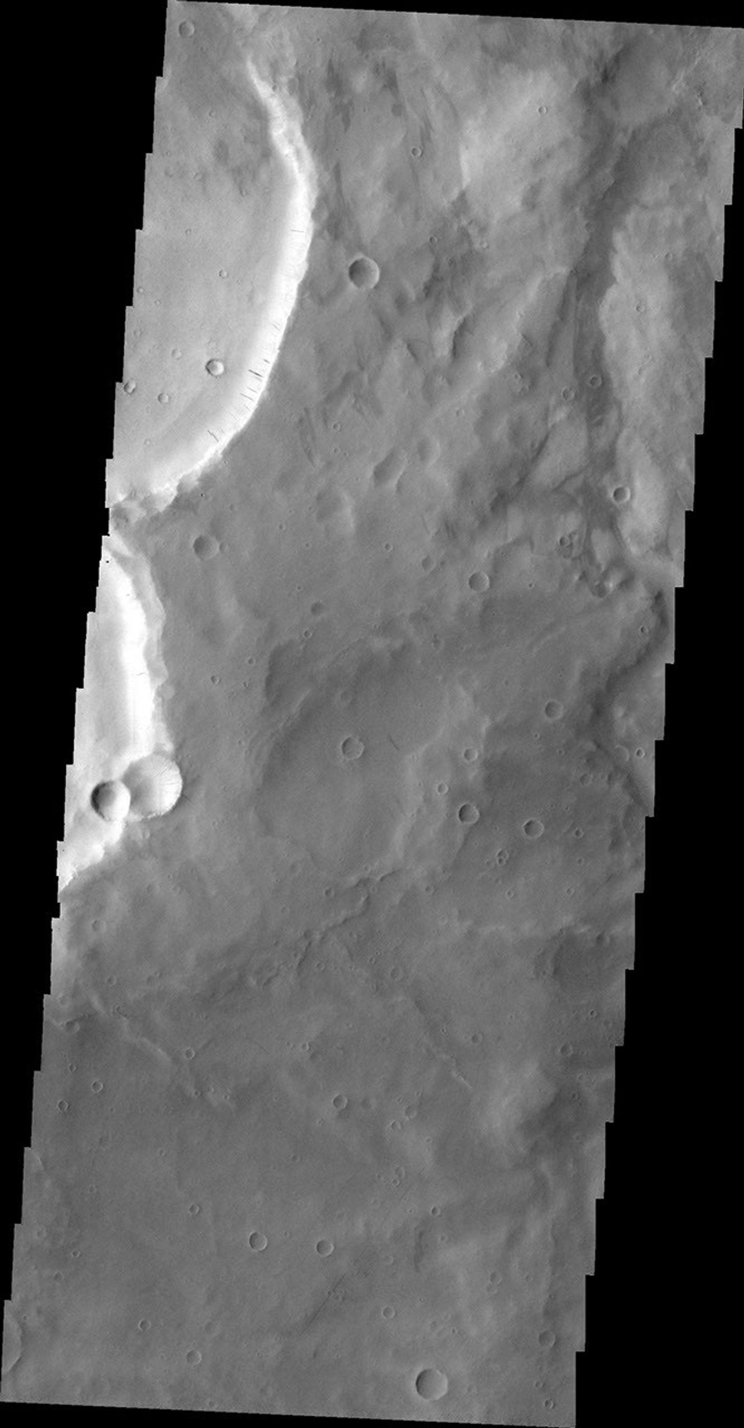 The dark slope streaks in this image are located on the rim of an unnamed crater east of Schiaparelli Crater taken by NASA's 2001 Mars Odyssey spacecraft.