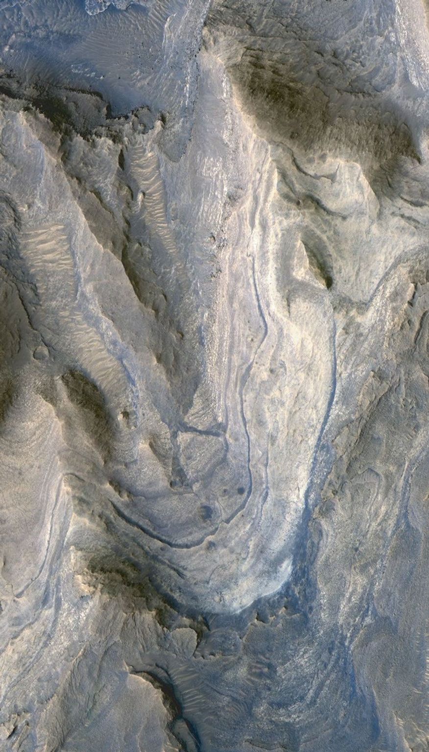 Layers of rock exposed in the lower portion of a tall mound near the center of Gale Crater on Mars exhibit variations in layer thickness and range between dark and light tones in this image taken by NASA's Mars Reconnaissance Orbiter.