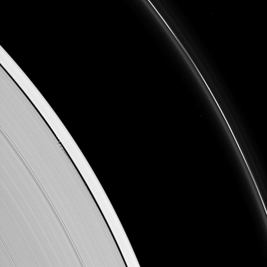 Tiny Daphnis appears as a bright dot in the Keeler Gap next to shadows cast by the moon and the edge waves it has created in the A ring in this image taken by NASA's Cassini spacecraft before Saturn's August 2009 equinox.