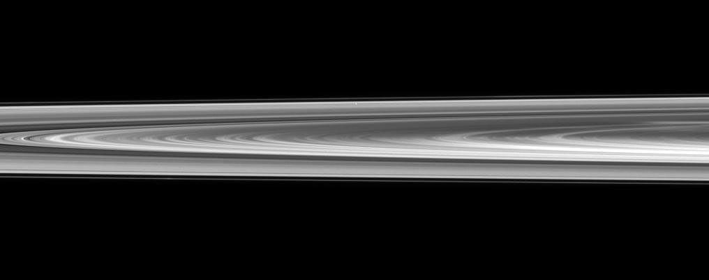 Pan is nearly lost within Saturn's rings in this view captured by NASA's Cassini spacecraft of a small section of the rings from just above the ringplane.