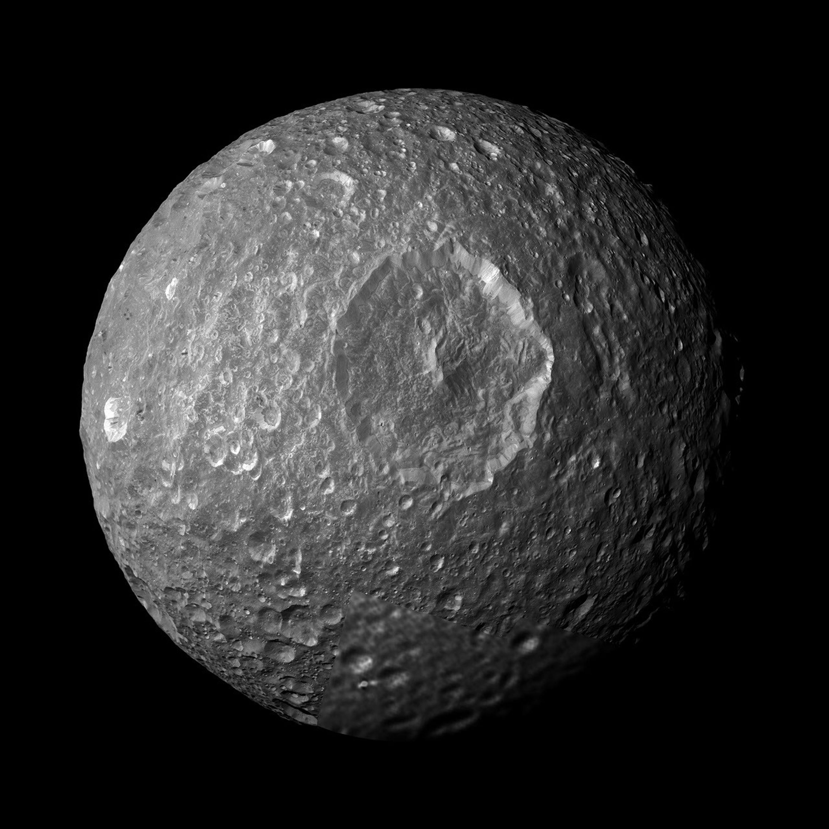 This mosaic, created from images taken by NASA's Cassini spacecraft, looks straight at Saturn's moon Mimas' huge Herschel Crater revealing bright-walled craters, with floors and surroundings about 20 percent darker than the steep crater walls.