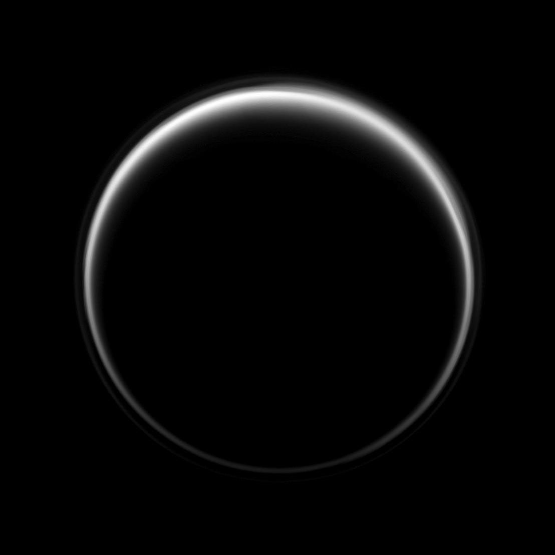 NASA's Cassini spacecraft looks toward the dark side of Titan as a circle of light is produced by sunlight scattering through the periphery of the atmosphere of Saturn's largest moon. A detached, high-altitude global haze layer encircles the moon.
