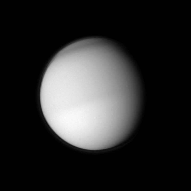 Two different seasons on Titan in different hemispheres can be seen in this image. The moon's northern half appears slightly darker than the southern half in this view taken in visible blue light by NASA's Cassini spacecraft.