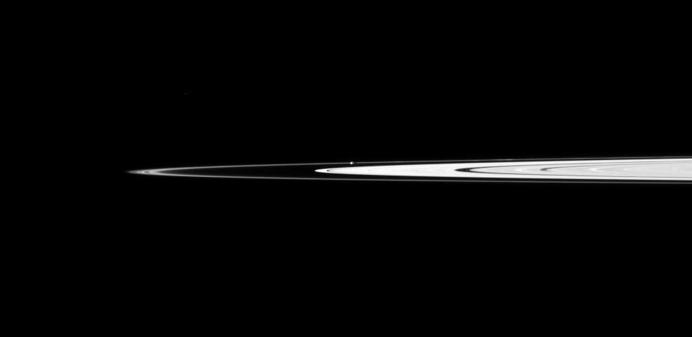Saturn's small, potato-shaped moon Prometheus orbits between the main rings and the thin F ring in this view captured by NASA's Cassini spacecraft.