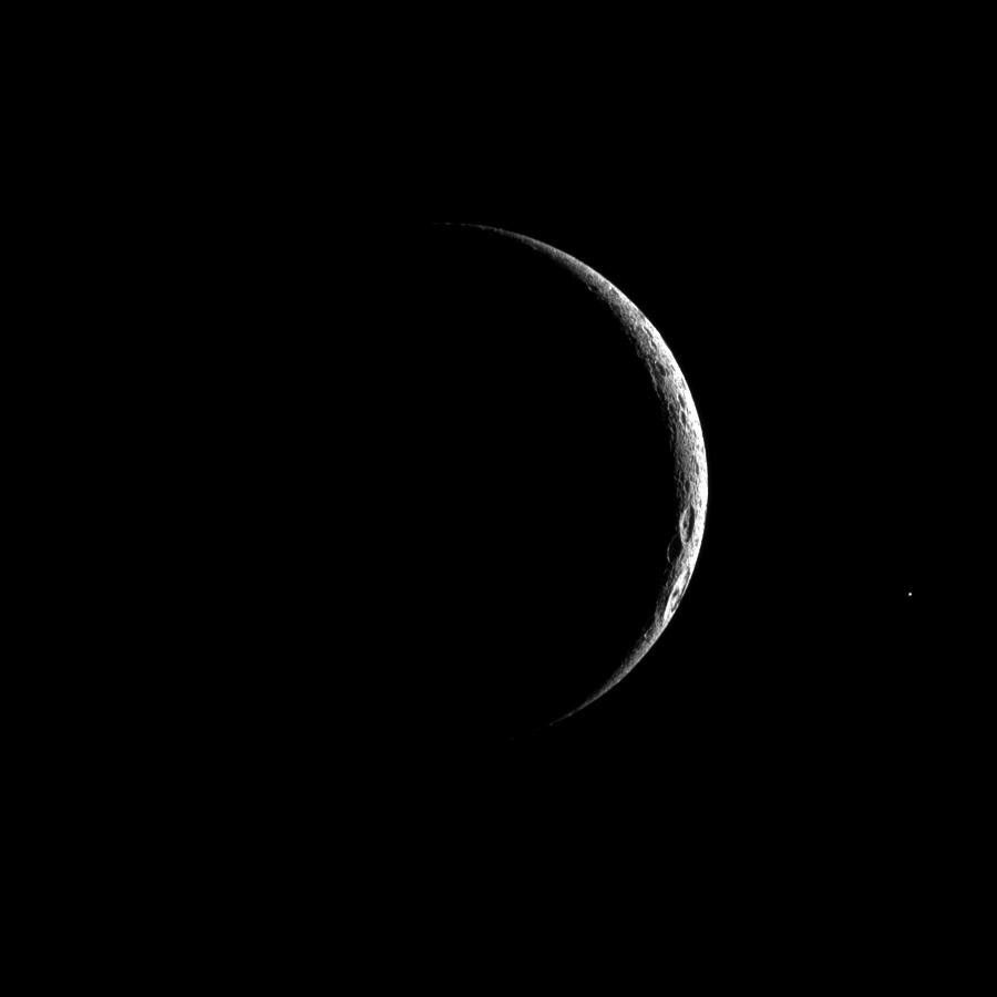 A thin crescent of cratered terrain is illuminated on Saturn's third largest moon, Dione in this image captured by NASA's Cassini spacecraft.