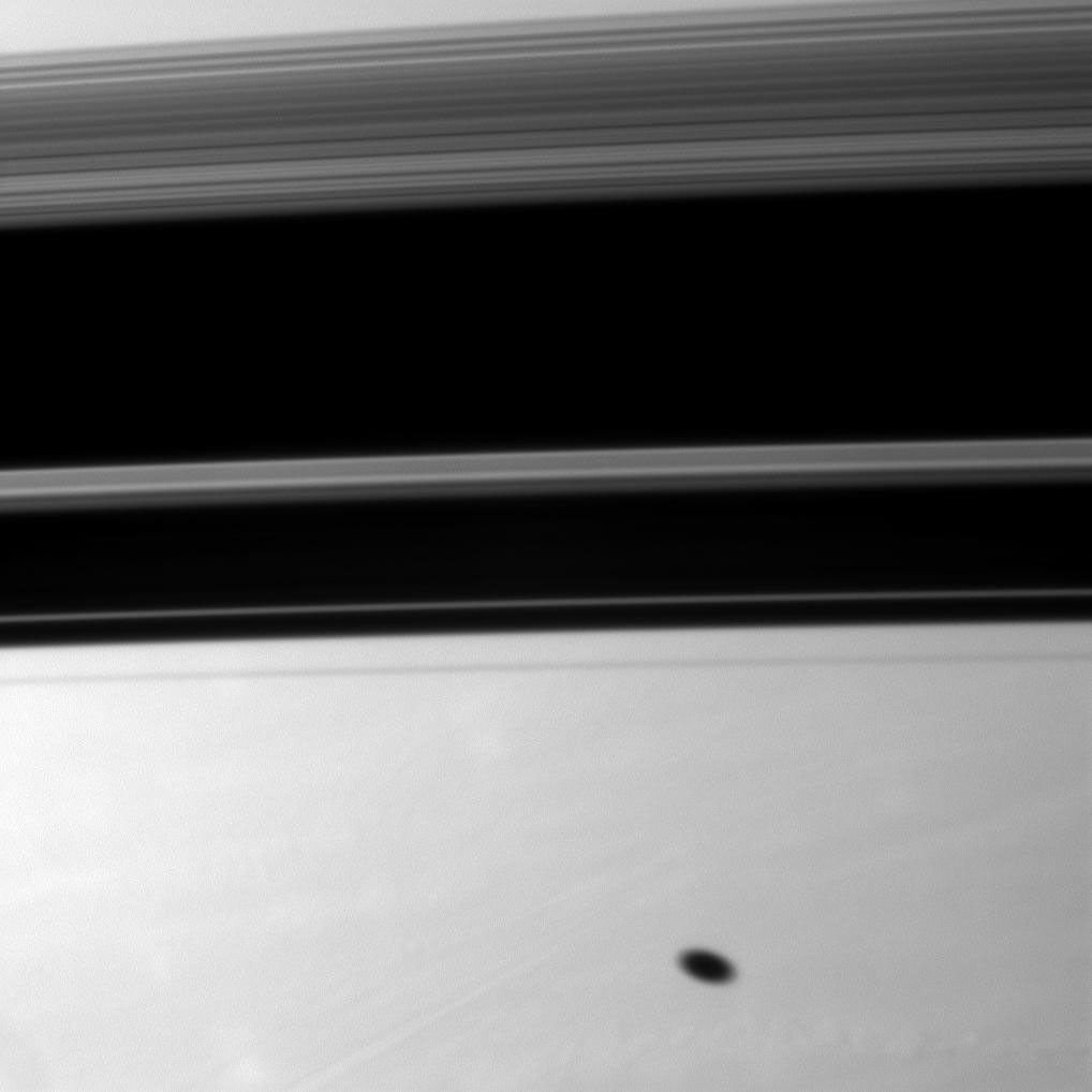Saturn's moon Mimas casts a elliptical shadow on the planet south of the larger, wider shadows cast by the planet's rings. Mimas and the rings are not shown in this image captured by NASA's Cassini spacecraft.