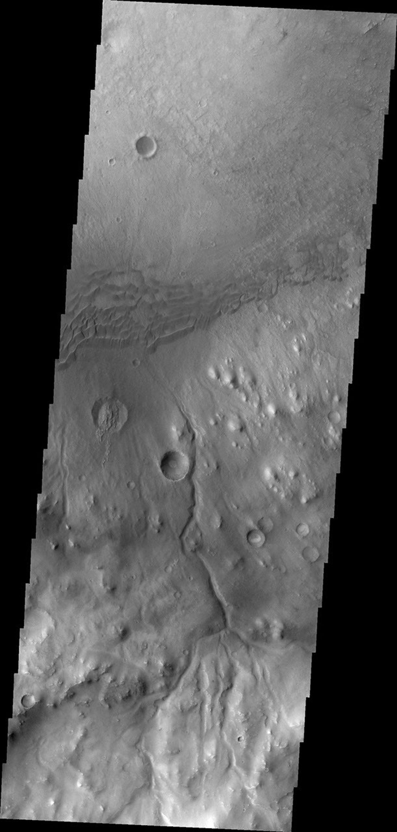 This image, taken by NASA's 2001 Mars Odyssey spacecraft, shows a portion of the rim and floor of Gale Crater. The crater rim is dissected by a channel, and dunes are located on the floor at the rim margin.