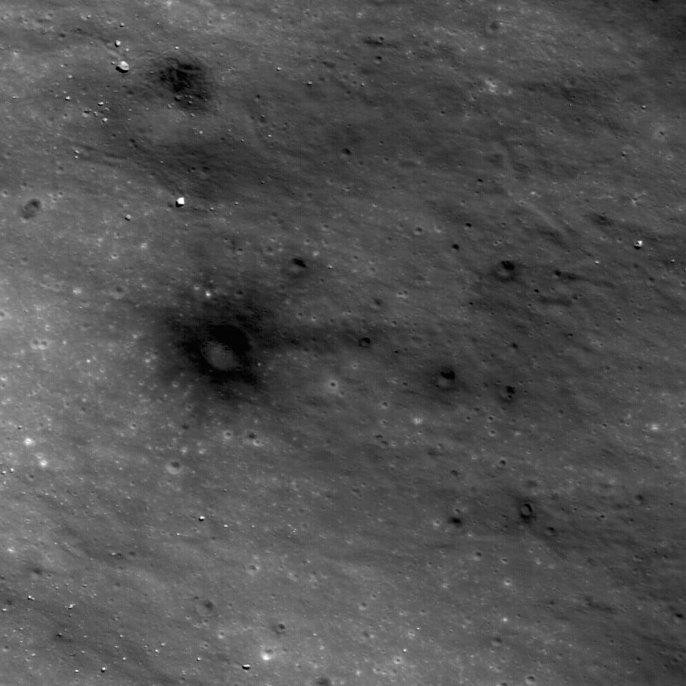 This image from NASA's Lunar Reconnaissance Orbiter shows dark materials excavated by later small impacts show up clearly on the bright ejecta of a small lunar crater to the west.
