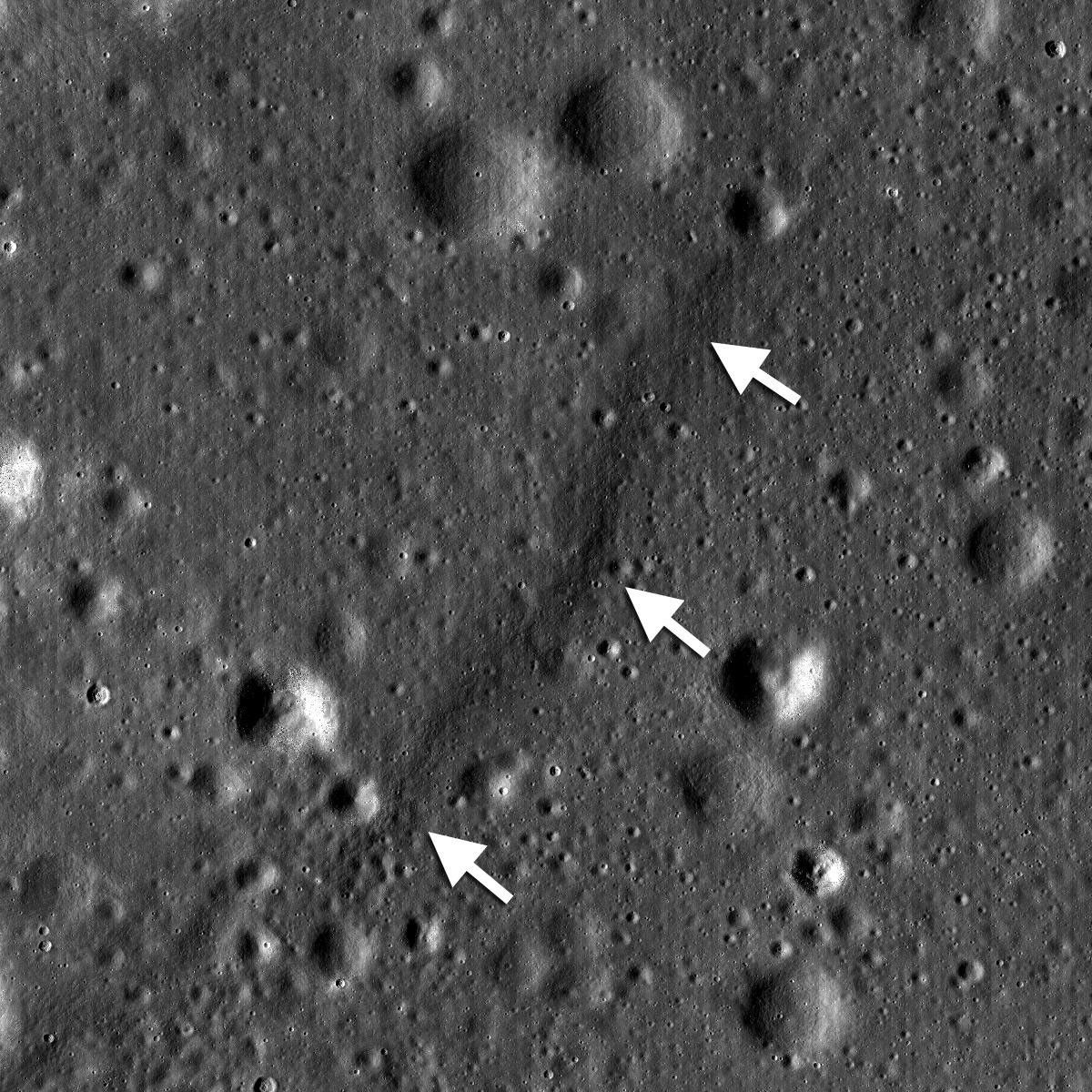 NASA's Lunar Reconnaissance Orbiter shows a lobate scarp in the mare basalts of Aitken crater on the lunar farside (arrows).