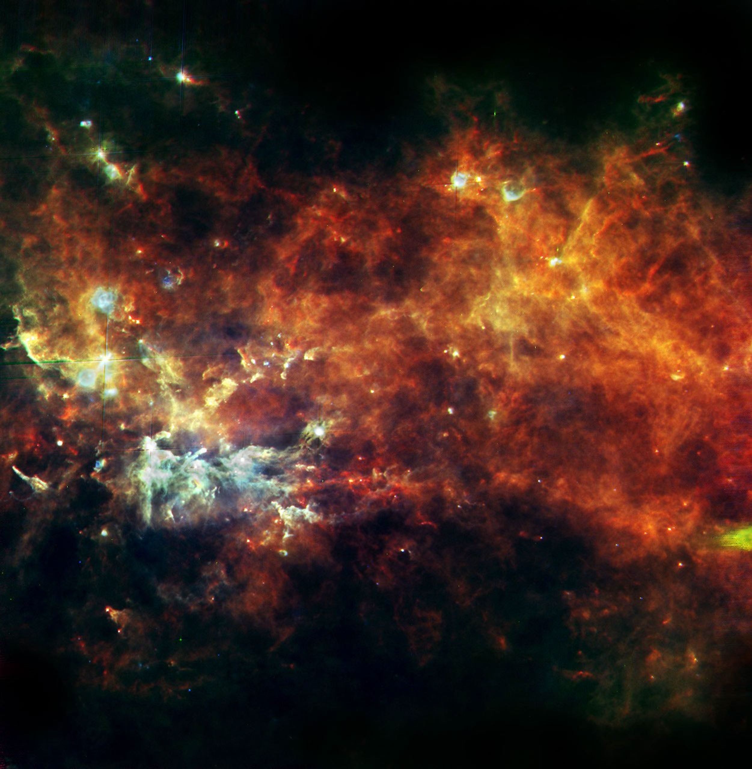 This image from NASA's Herschel, in the constellation of Vulpecula, shows an entire assembly line of newborn stars. The diffuse glow reveals the widespread cold reservoir of raw material that our Milky Way galaxy has in stock for building stars.