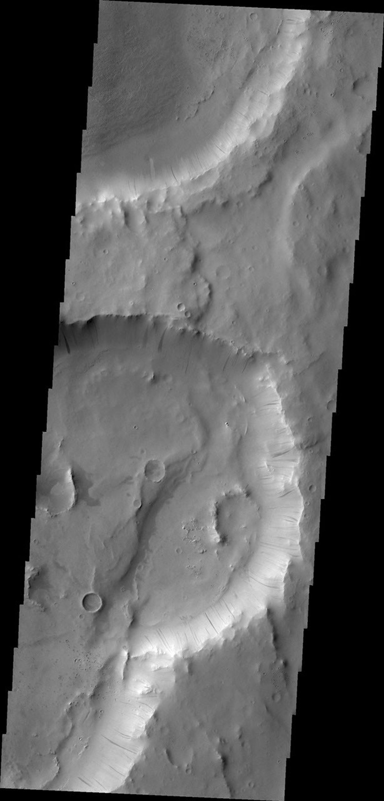 Dark slope streaks are visible on the rim of this crater in Terra Sabaea in this image captured by NASA's 2001 Mars Odyssey.
