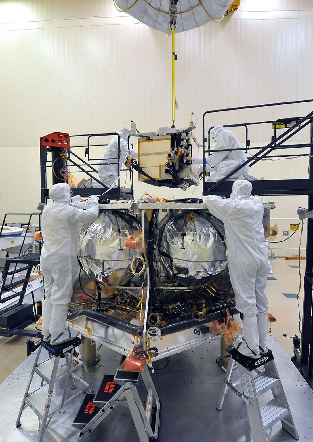 Workers place the special radiation vault for NASA's Juno spacecraft onto the propulsion module. The whole vault, with more than 20 electronic assemblies inside, weighs about 200 kilograms (500 pounds).