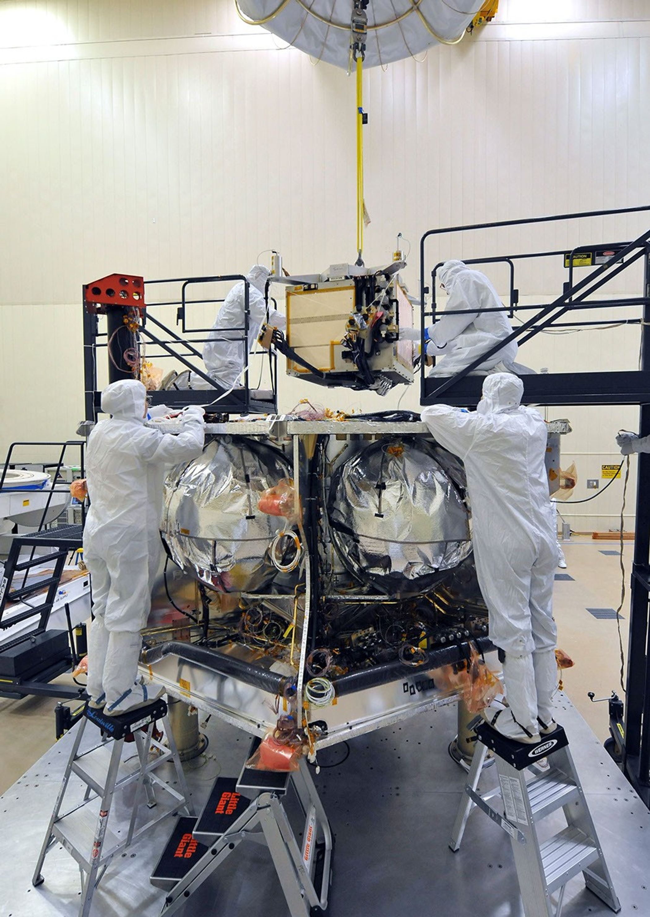 Workers place the special radiation vault for NASA's Juno spacecraft onto the propulsion module. The whole vault, with more than 20 electronic assemblies inside, weighs about 200 kilograms (500 pounds).