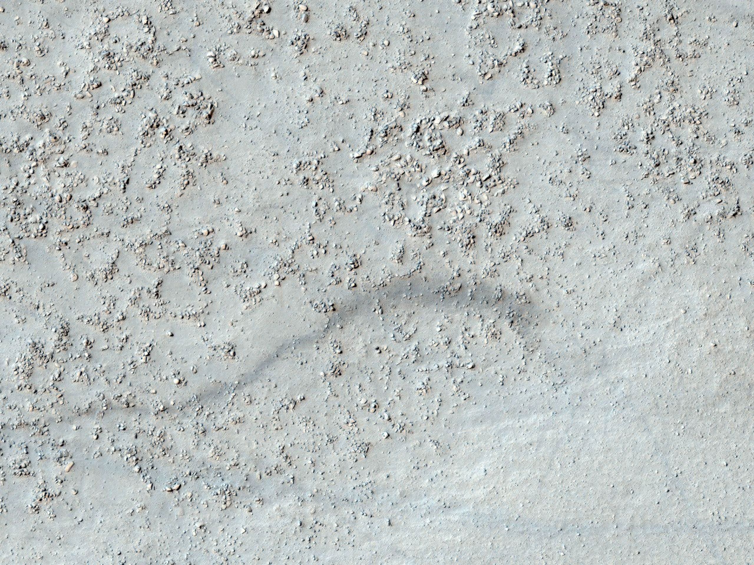 This image from NASA's Mars Reconnaissance Rover shows a degraded impact crater in the southern highlands. Part of the crater rim is visible at the top and bottom of the image, with the boulder-covered crater floor in the center.