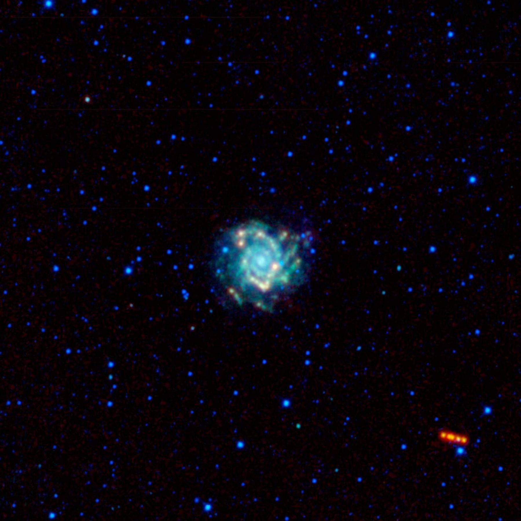 Galaxy Messier 74, with its spiral arms seen face-on, is in the center of this image captured by NASA's Wide-field Infrared Survey Explorer, or WISE, while an asteroid tracks its way across the sky.