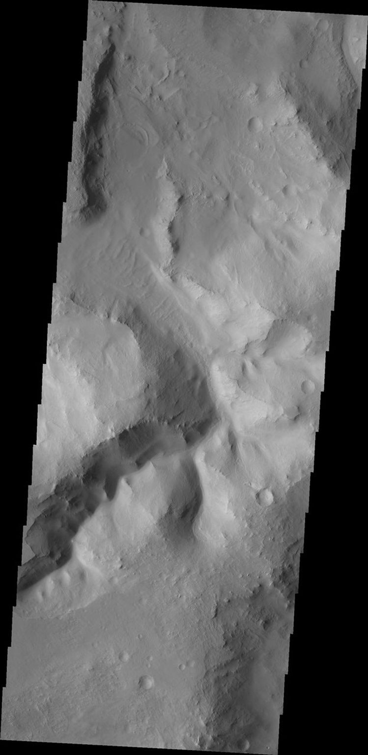 This image from NASA's Mars Odyssey shows a channel within a region of chaos NW of Nili Fossae; on Mars, the term 'chaos' terrain is given to regions where areas of the surface are broken up into multiple mesas divided by low valleys.