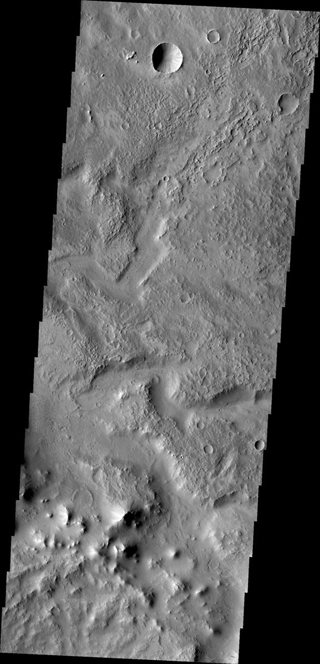 Tikhonravov Crater is a large, old crater in Terra Sabaea. The crater is pockmarked by numerous younger craters and other features. This image from NASA's Mars Odyssey shows a channel within Tikhonravov Crater.
