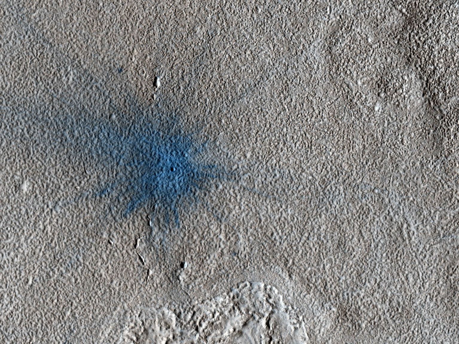 This image from NASA's Mars Reconnaissance Orbiter shows an approximately 7-meter diameter fresh crater and dark ejecta blanket. These small impact craters continue to form on Mars, and are most easily recognized in areas covered by bright dust.