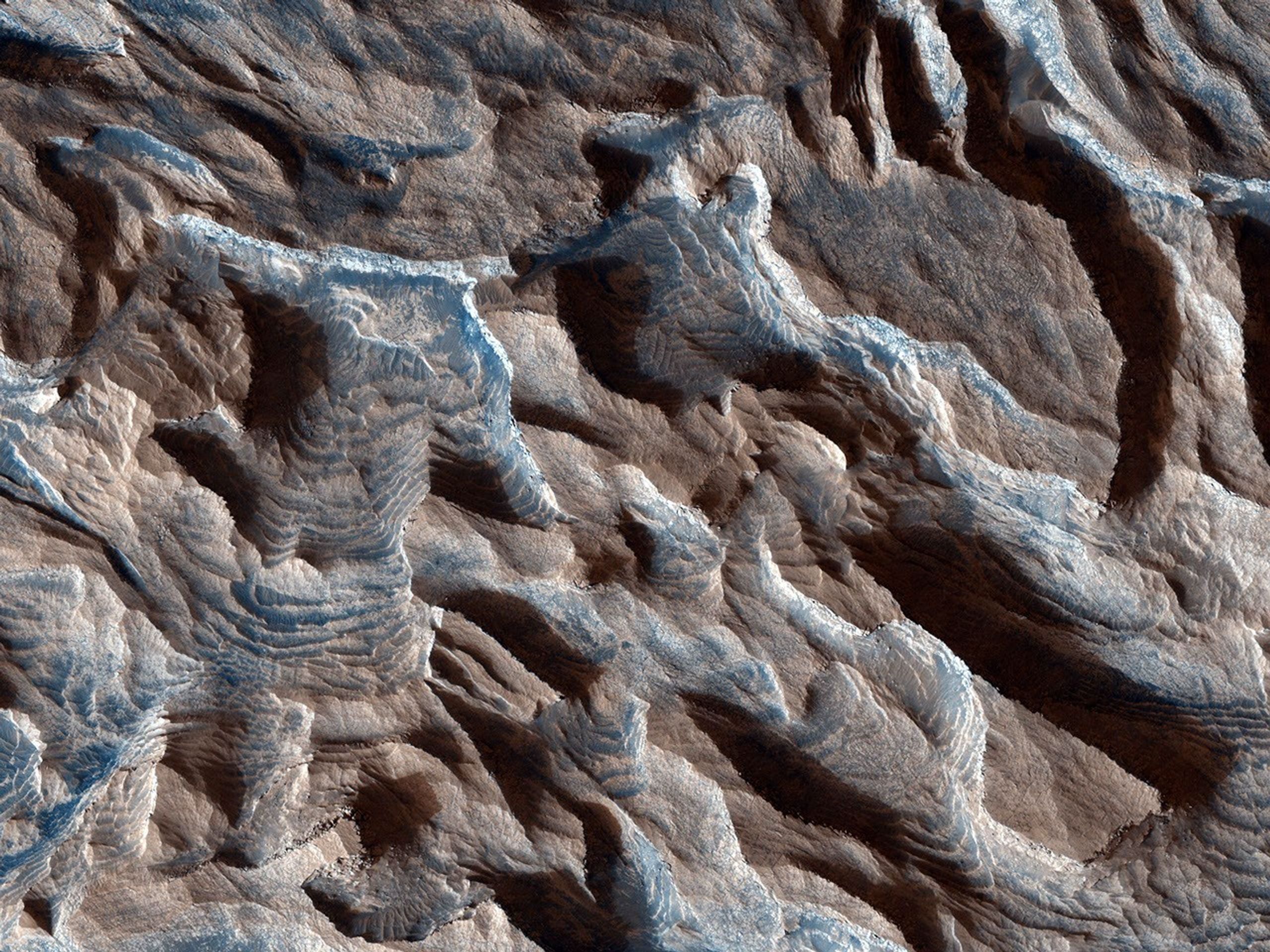 This observation from NASA's Mars Reconnaissance Orbiter shows Becquerel Crater, one of several impact craters in Arabia Terra that have light-toned layered deposits along the crater floor. The layers appear to be only a few meters thick.