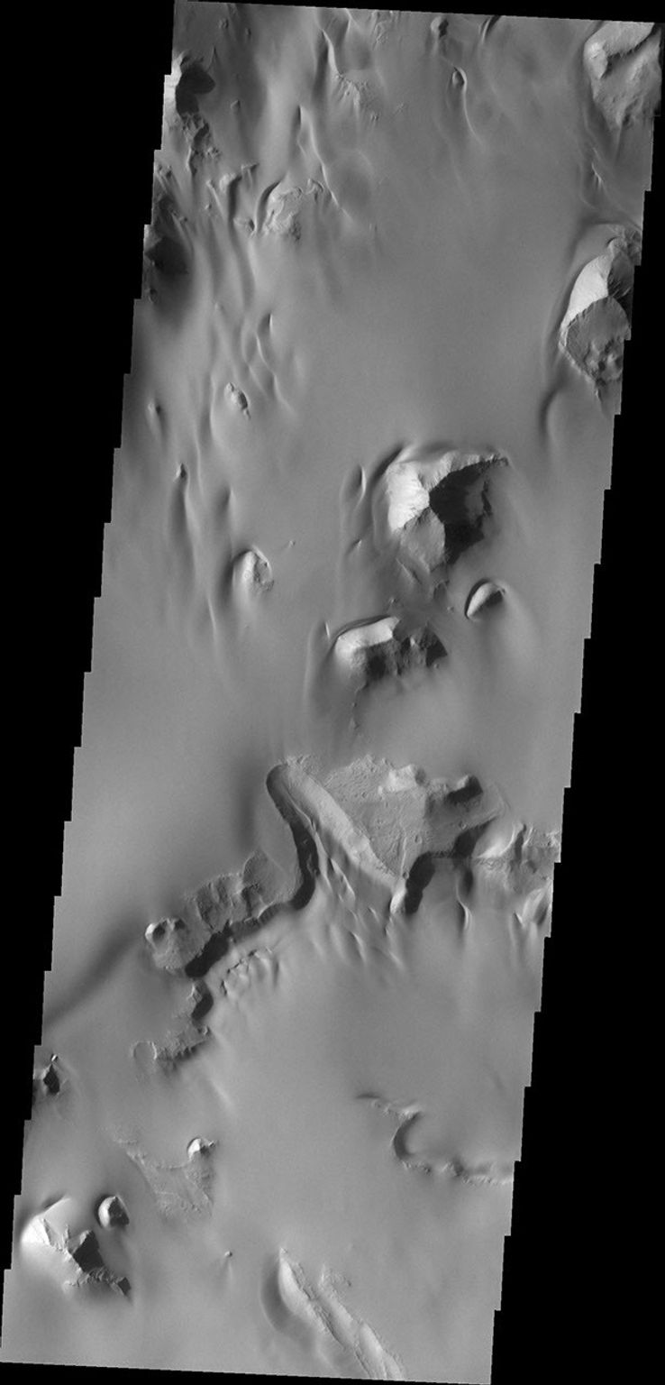 The amount of sand in this region of Juventae Chasma has coalesced into a sand sheet, rather than individual dune forms. Wind continues to sculpt the sand around high standing hills in this image from NASA's Mars Odyssey.