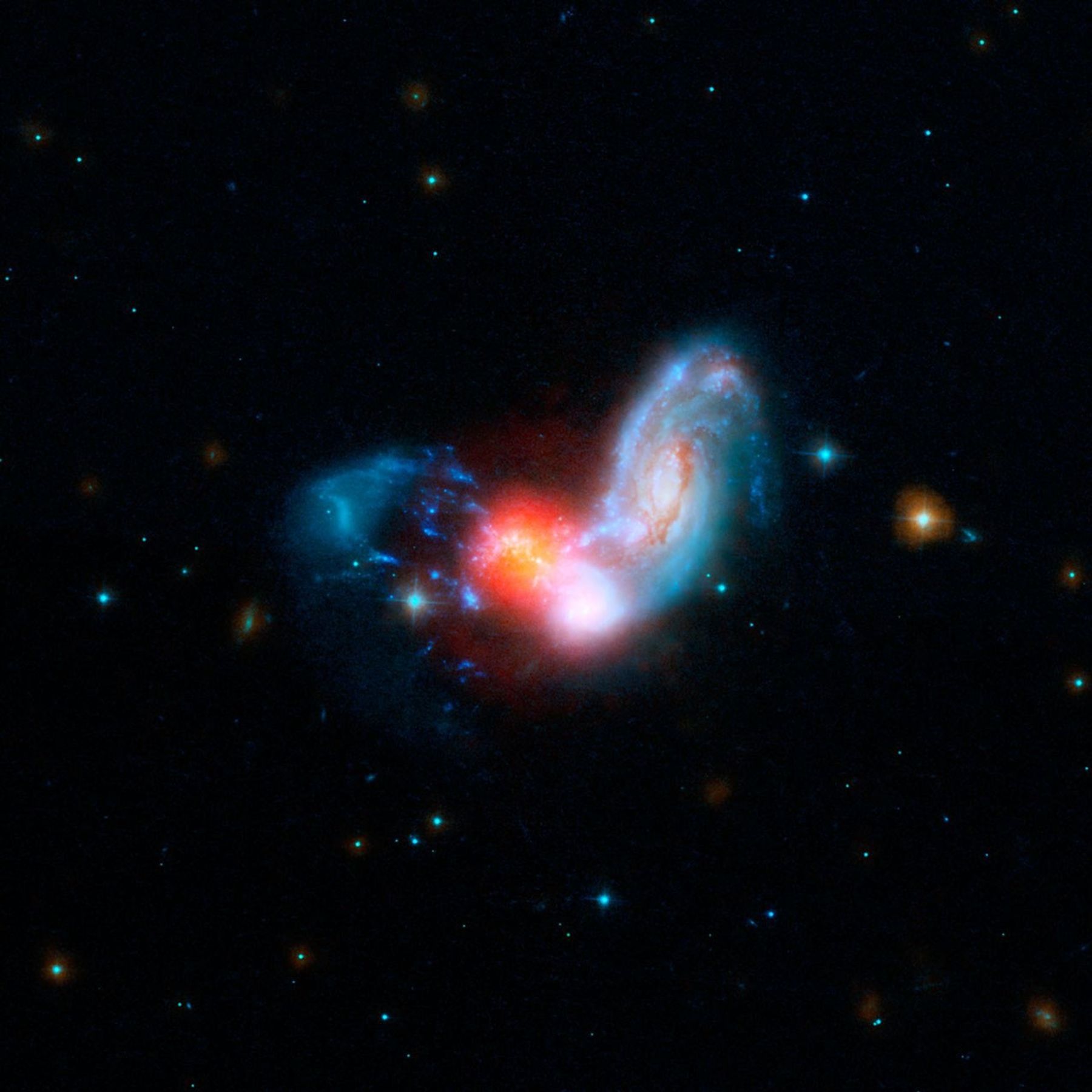 A brilliant burst of star formation is revealed in this image combining observations from NASA's Spitzer and Hubble Space Telescopes. The collision of two spiral galaxies has triggered this luminous starburst.