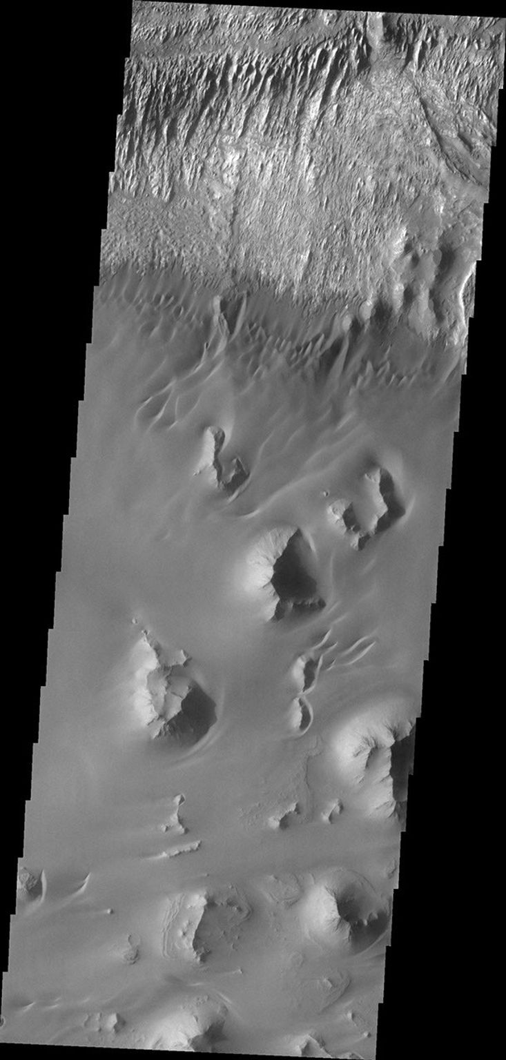 This image from NASA's Mars Odyssey of the floor of Ganges Chasma shows eroded fill material and extensive sand deposits.