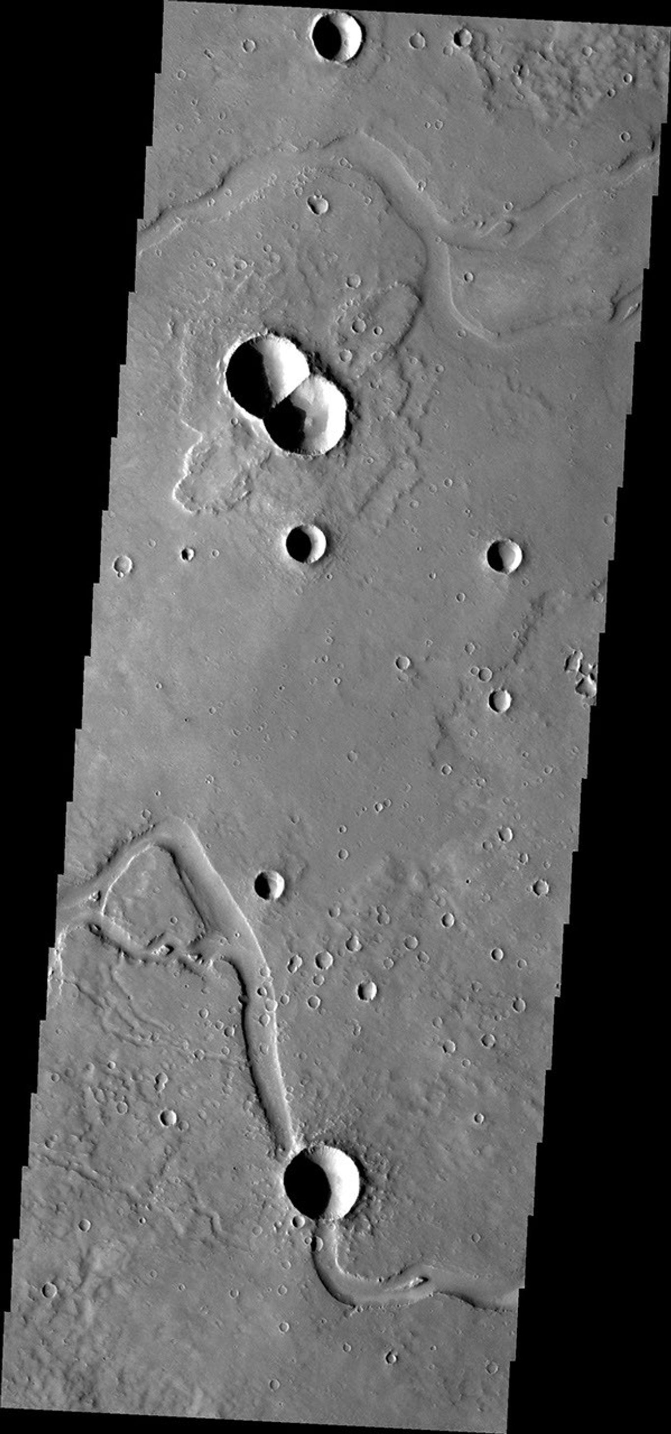 This image from NASA's Mars Odyssey is of a doublet crater located in Utopia Planitia, near the Elysium Volcanic region. Doublet craters are formed by simultaneous impact of a meteor that broke into two pieces prior to hitting the surface.