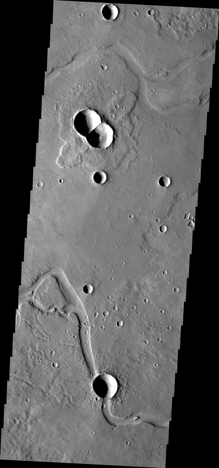 This image from NASA's Mars Odyssey is of a doublet crater located in Utopia Planitia, near the Elysium Volcanic region. Doublet craters are formed by simultaneous impact of a meteor that broke into two pieces prior to hitting the surface.