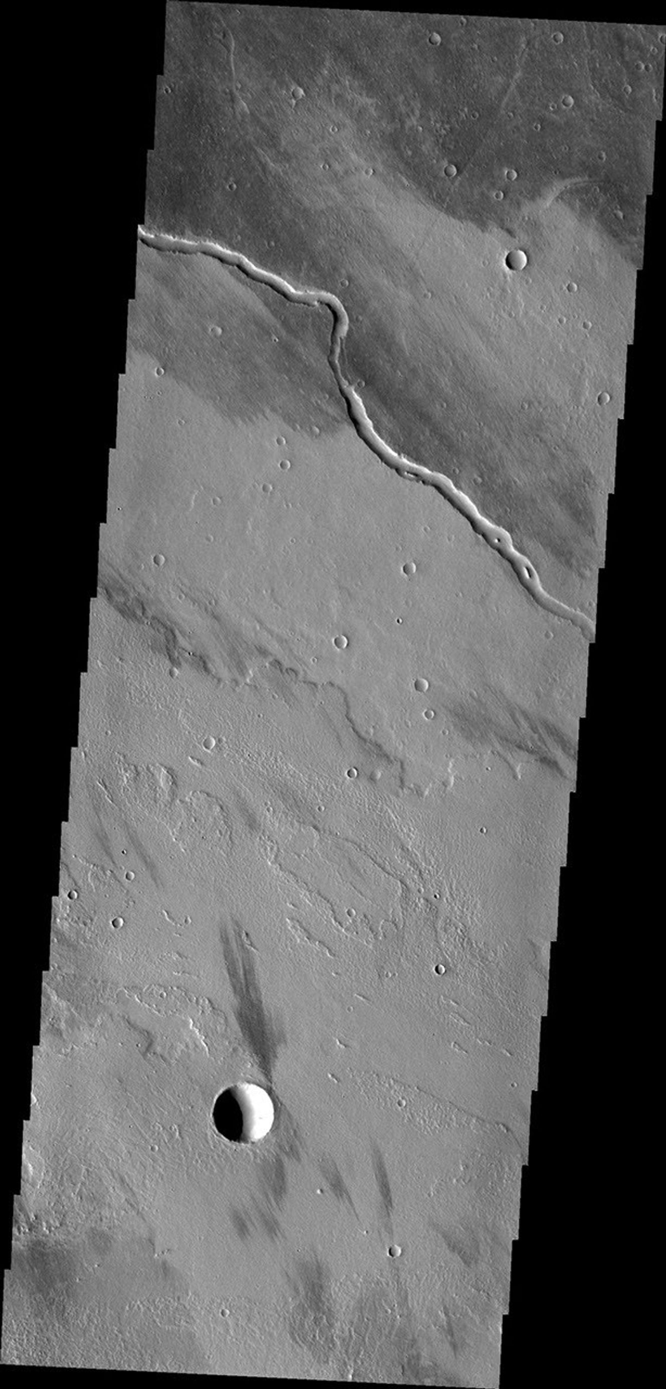 The channel seen in this image from NASA's Mars Odyssey is located within the Tharsis volcanic flows. It was most likely carved by the flow of molten lava.