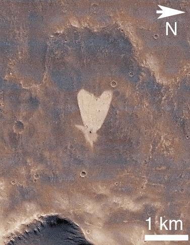 This picture of a heart-shaped feature in Arabia Terra on Mars was taken on May 23, 2010, by NASA's Mars Reconnaissance Orbiter. A small impact crater near the tip of the heart is responsible for the formation of the bright, heart-shaped feature.