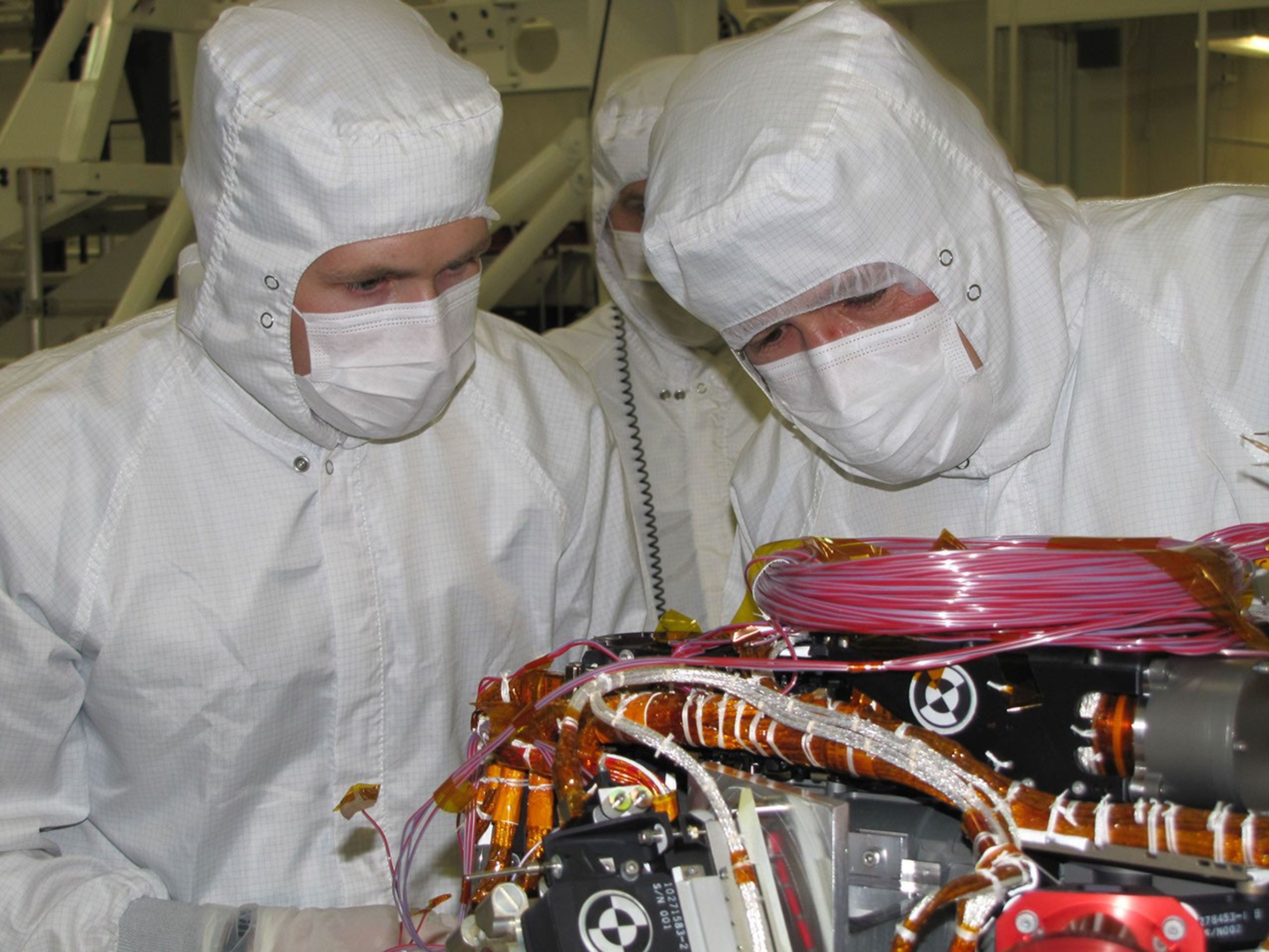 Grad student Nicholas Boyd (left) and Principal Investigator Ralf Gellert, both of the University of Guelph, Ontario, Canada, prepare for the installation of the Alpha Particle X-ray Spectrometer sensor head during testing at NASA's JPL.