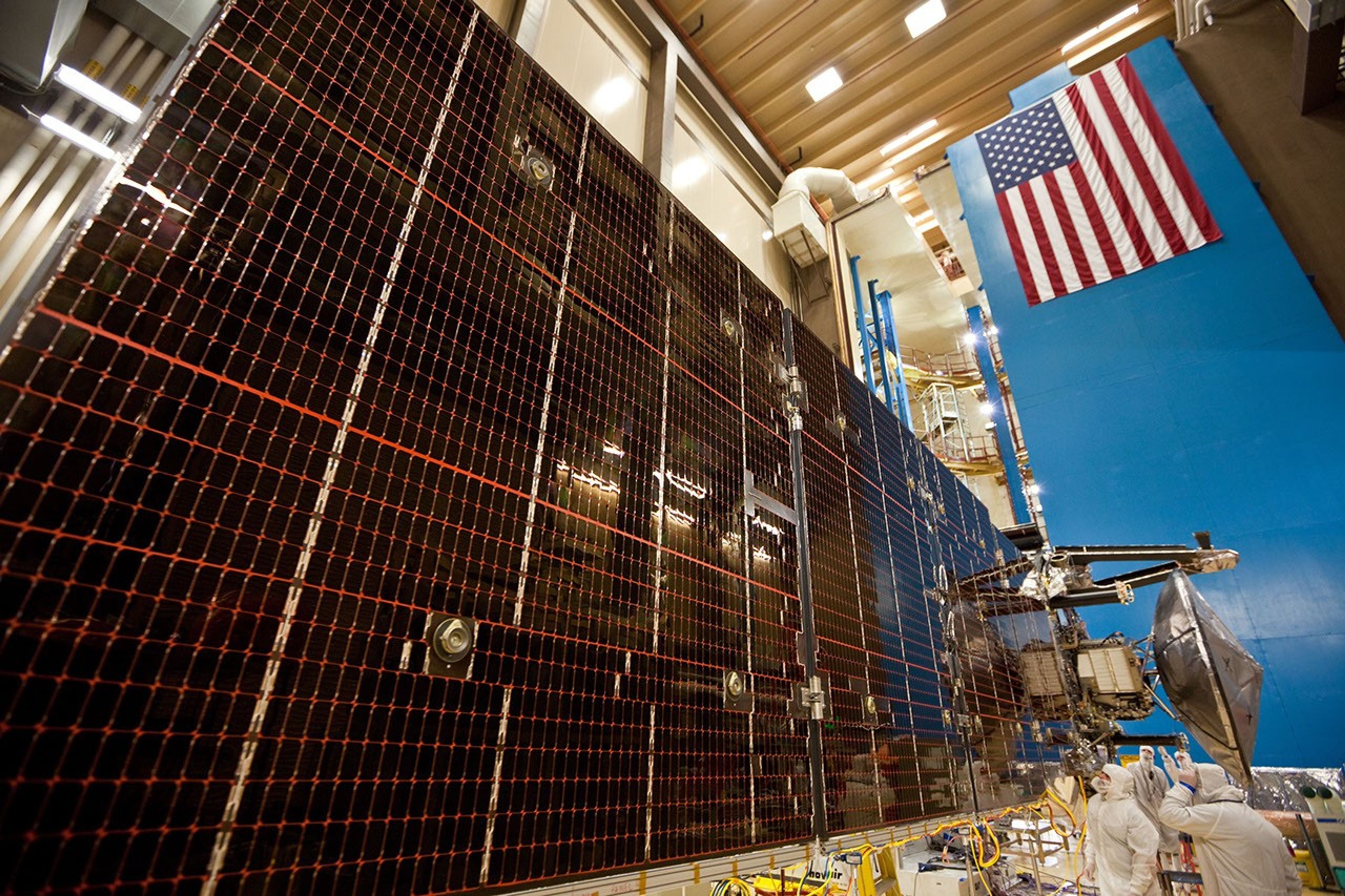 Technicians test the deployment of one of the three massive solar arrays that power NASA's Juno spacecraft.