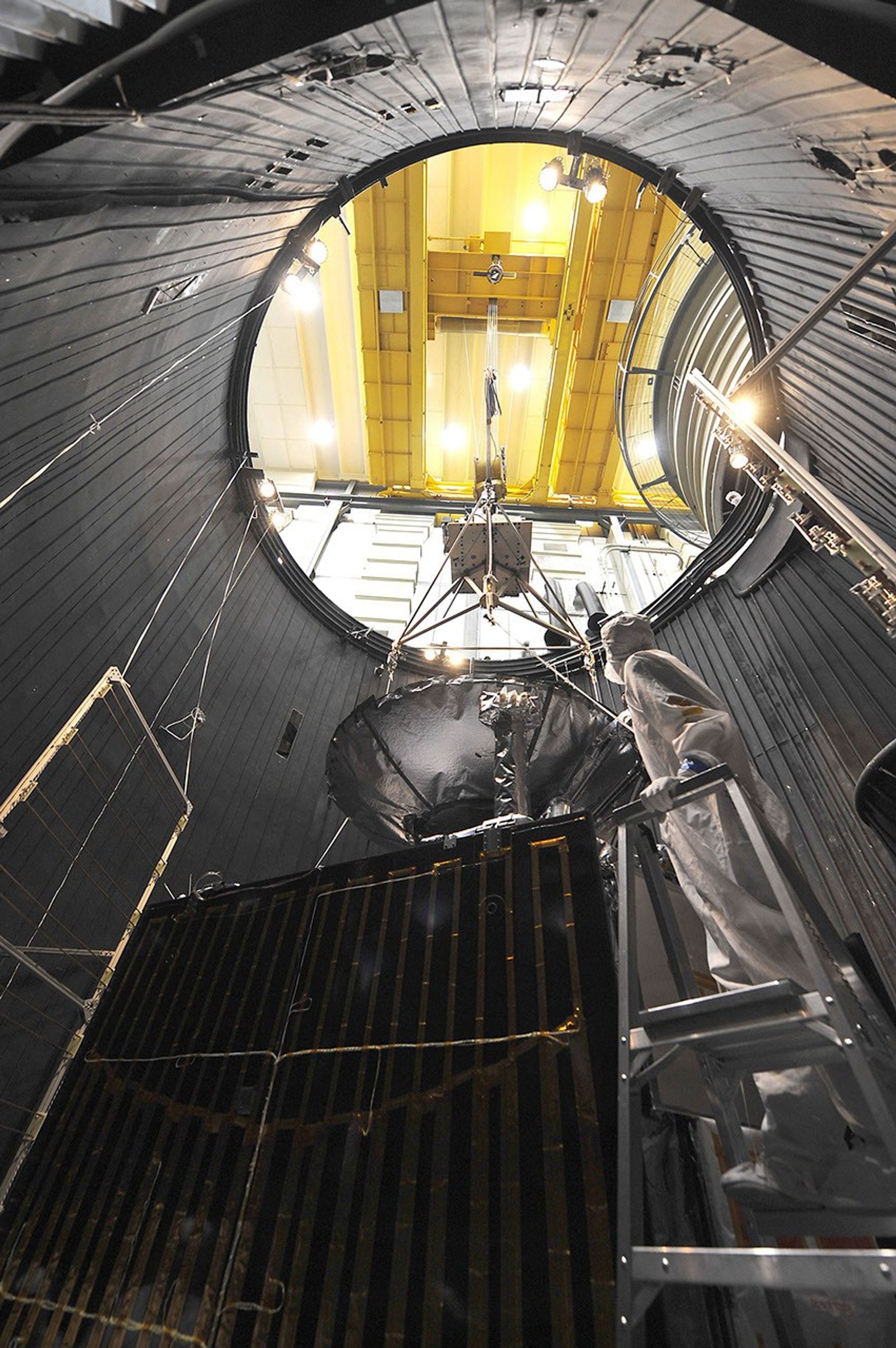 This image of NASA's Juno spacecraft was taken as the vehicle completed its thermal vacuum chamber testing. A technician is attaching the lifting equipment in preparation for hoisting the 1,588-kilogram (3,500-pound) spacecraft out of the chamber.
