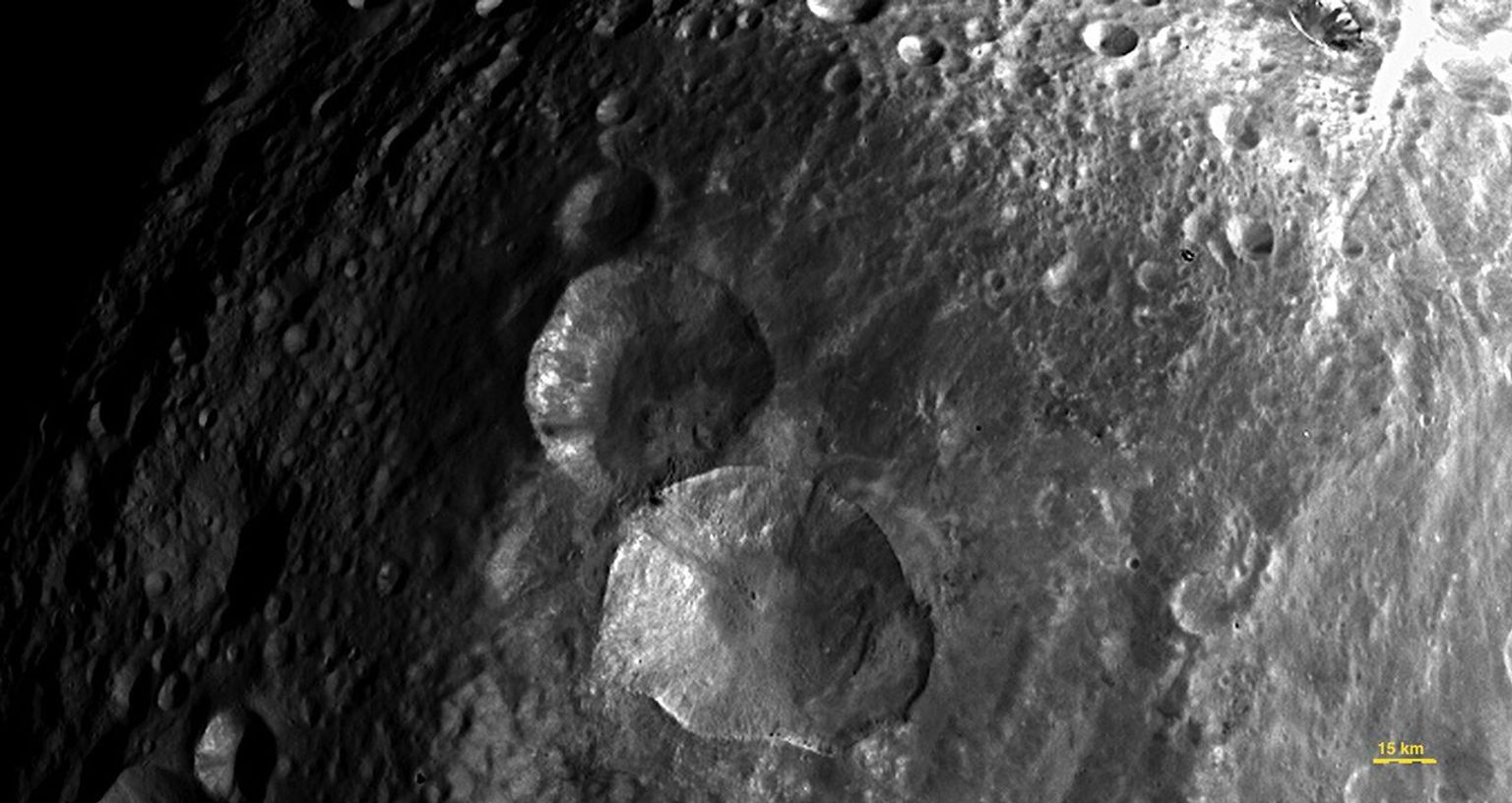 In this image, obtained by the framing camera on NASA's Dawn spacecraft, a set of three craters, informally nicknamed 'Snowman' by the camera's team members, is located in the northern hemisphere of Vesta.