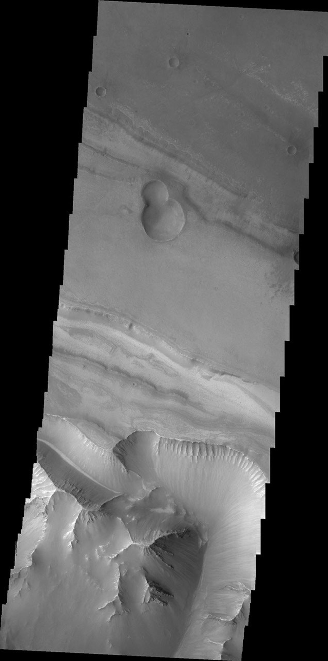 This image captured by NASA's 2001 Mars Odyssey spacecraft shows the region between Candor Chasma and Melas Chasma.