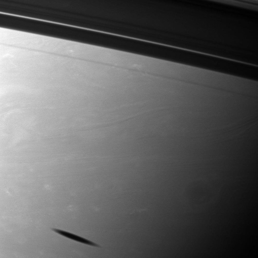 The shadow of the moon Mimas creates a smudge on the southern hemisphere of Saturn in this view from NASA's Cassini spacecraft. Mimas does not appear here, but it does cast its shadow on the planet in the lower left of the image.