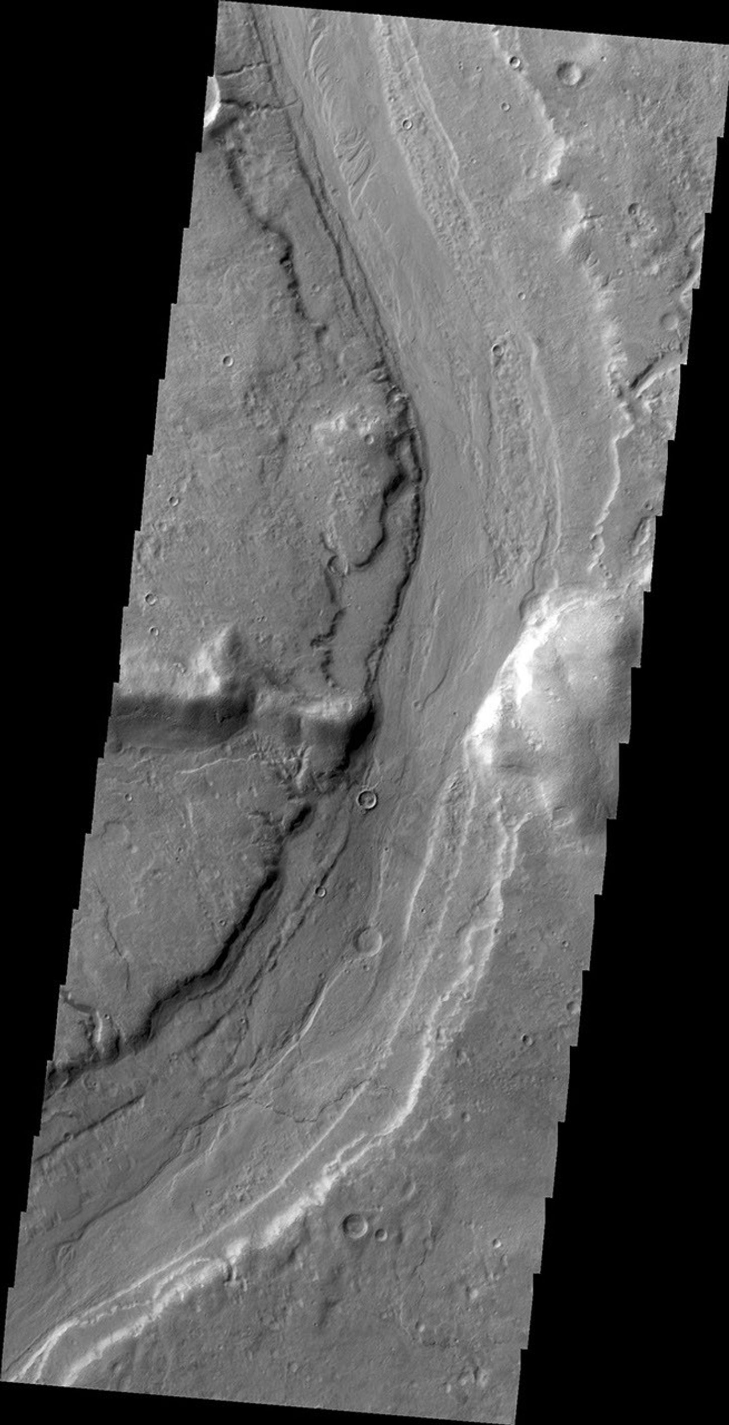 This image captured by NASA's 2001 Mars Odyssey spacecraft shows Reull Vallis where it cuts through the rim of Lipik Crater.