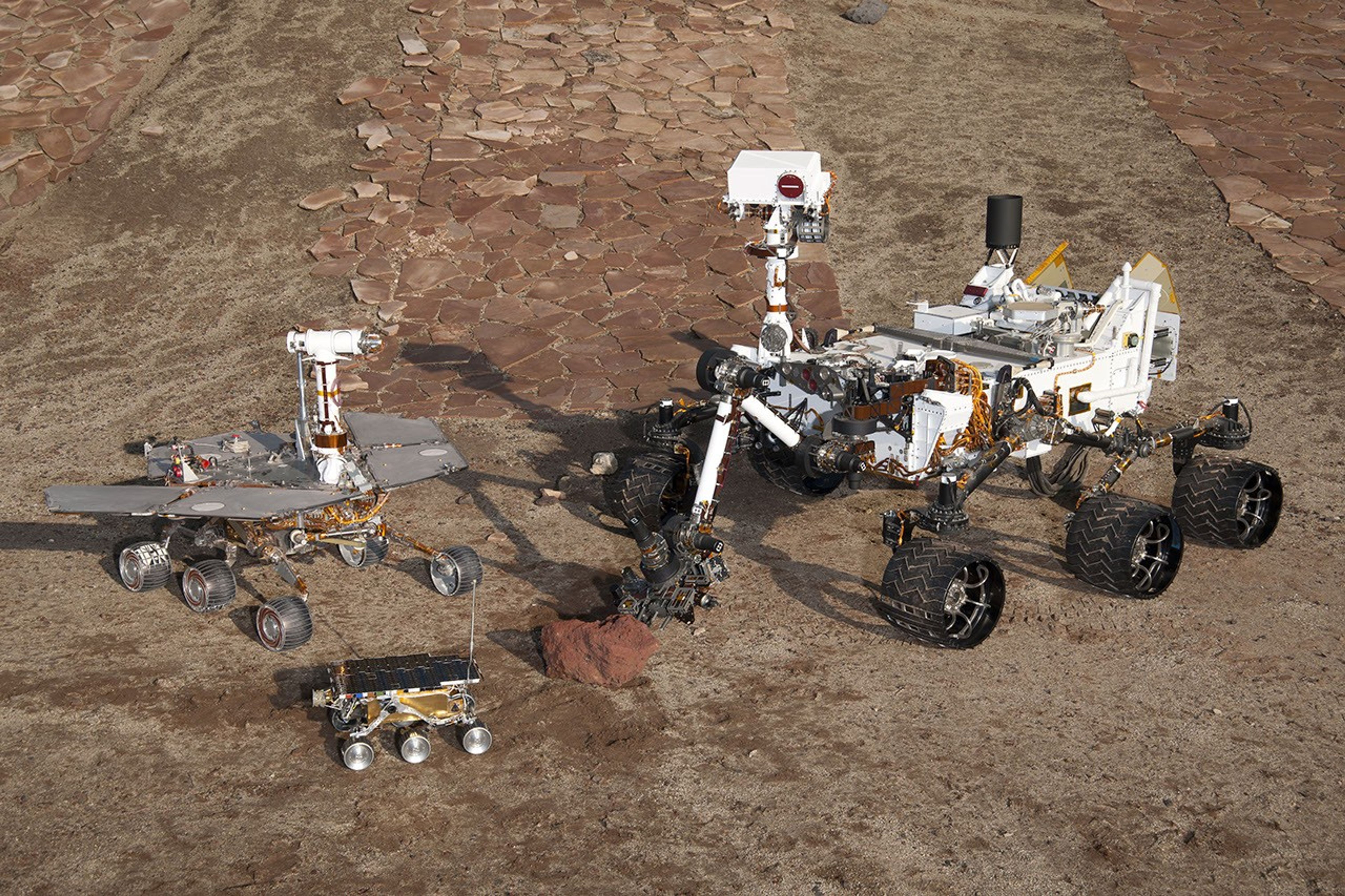 This grouping of two test rovers and a flight spare provides a graphic comparison of three generations of Mars rovers developed at NASA's Jet Propulsion Laboratory, Pasadena, Calif. The setting is JPL's Mars Yard testing area.