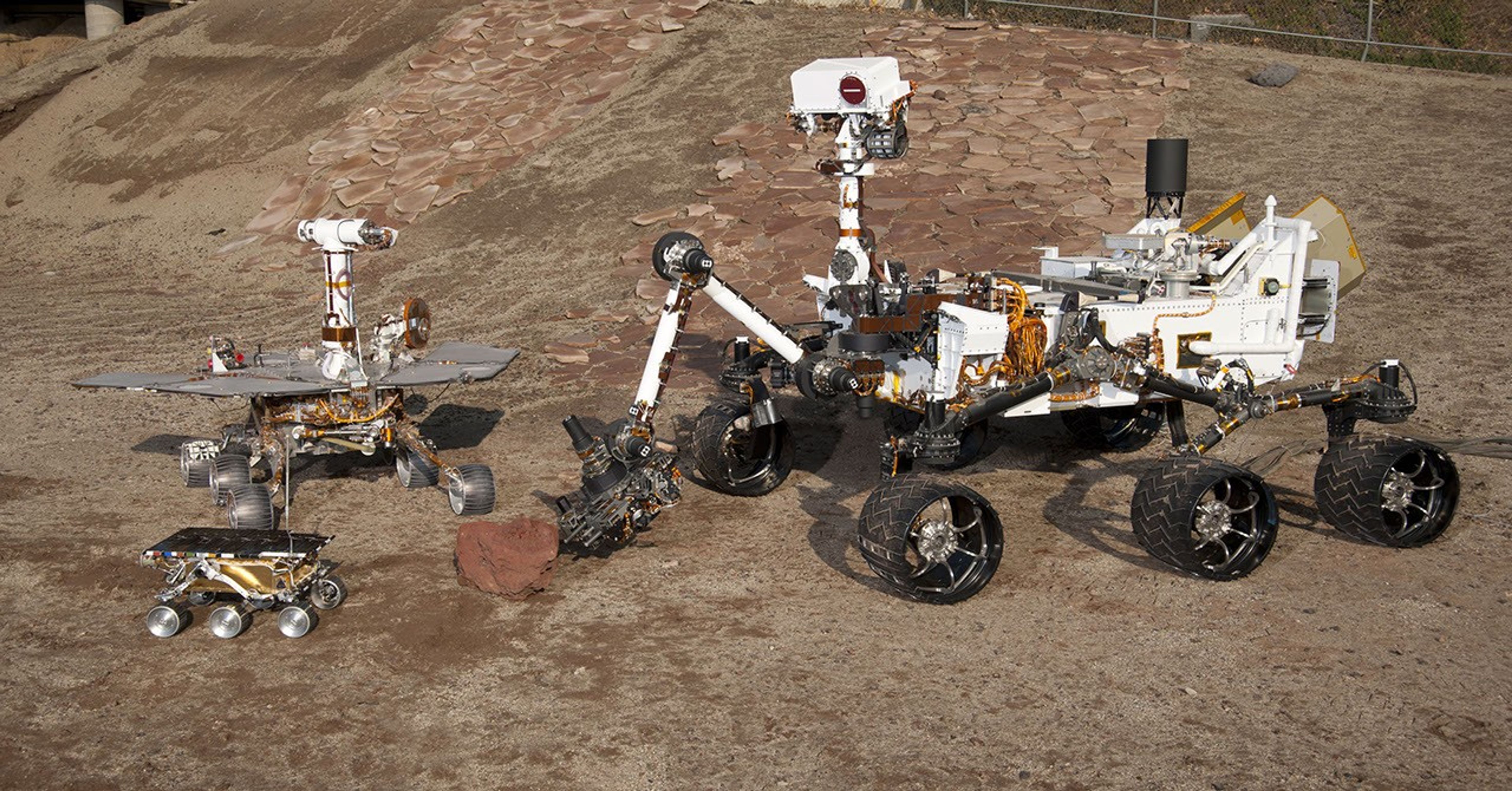 This grouping of two test rovers and a flight spare provides a graphic comparison of three generations of Mars rovers developed at NASA's Jet Propulsion Laboratory, Pasadena, Calif. The setting is JPL's Mars Yard testing area.